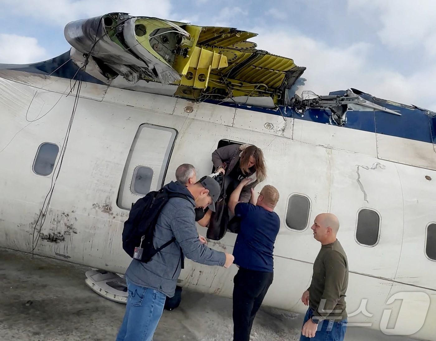 본문 이미지 - 17일&#40;현지시간&#41; 캐나다 토론토 피어슨 공항에 착륙 중 기체가 전복한 델타항공 여객기서 승객들이 대피를 하고 있다. 2025.02.19 ⓒ 로이터=뉴스1 ⓒ News1 우동명 기자