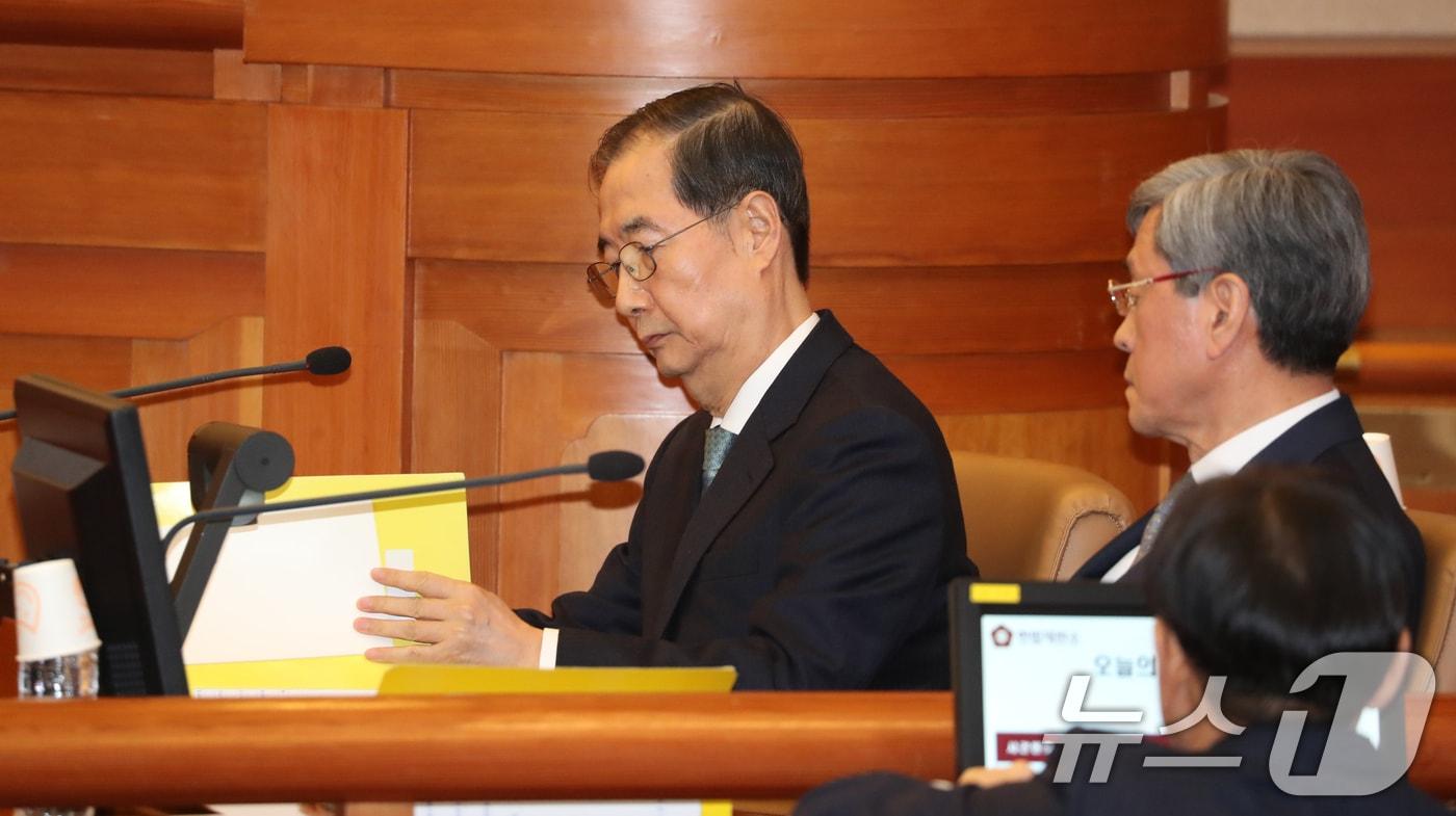 본문 이미지 - 한덕수 국무총리가 19일 오후 서울 종로구 헌법재판소에서 열린 탄핵심판 1차 변론에 출석해 자료를 보고 있다. (공동취재) 2025.2.19/뉴스1 ⓒ News1 박정호 기자