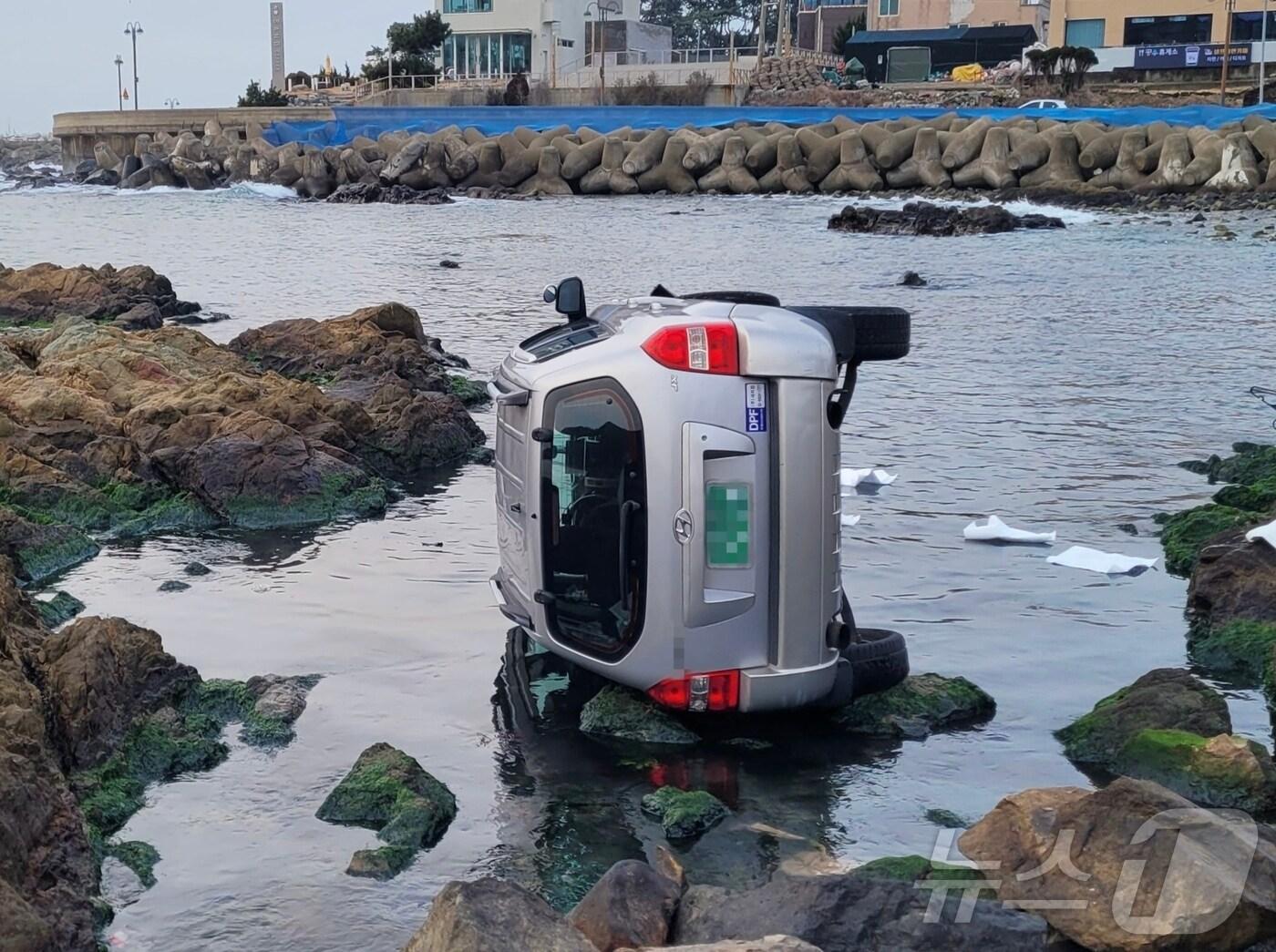 본문 이미지 - 2일 오전 7시 7분쯤 부산 기장군 시랑리 갯바위 인근에서 후진 중 차량이 바다에 빠졌다.(부산해경 제공) 