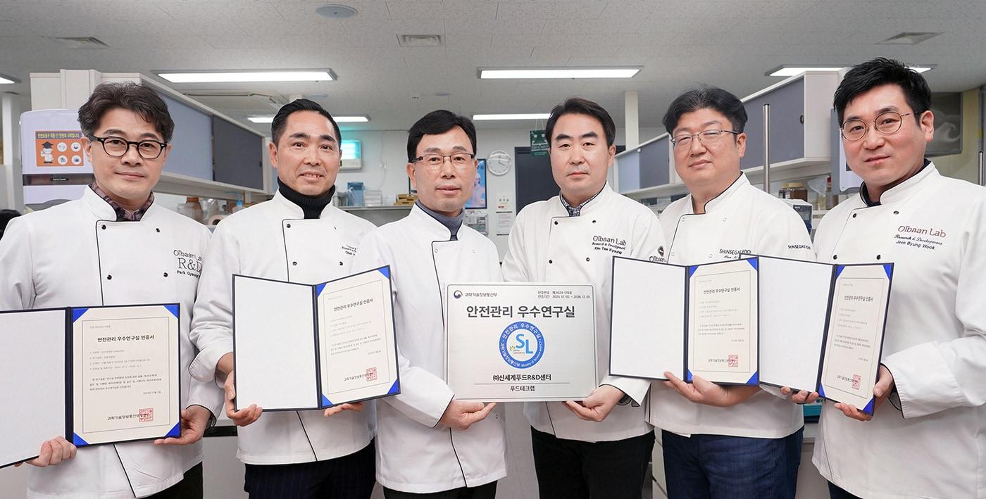 서울 성동구 성수동 신세계푸드 R&D센터에서 공병천 R&D담당(왼쪽에서 세번째)을 비롯한 관계자들이 과학기술정보통신부의 ‘안전관리 우수연구실’ 인증서를 들고 기념촬영을 하고 있다.(신세계푸드 제공)