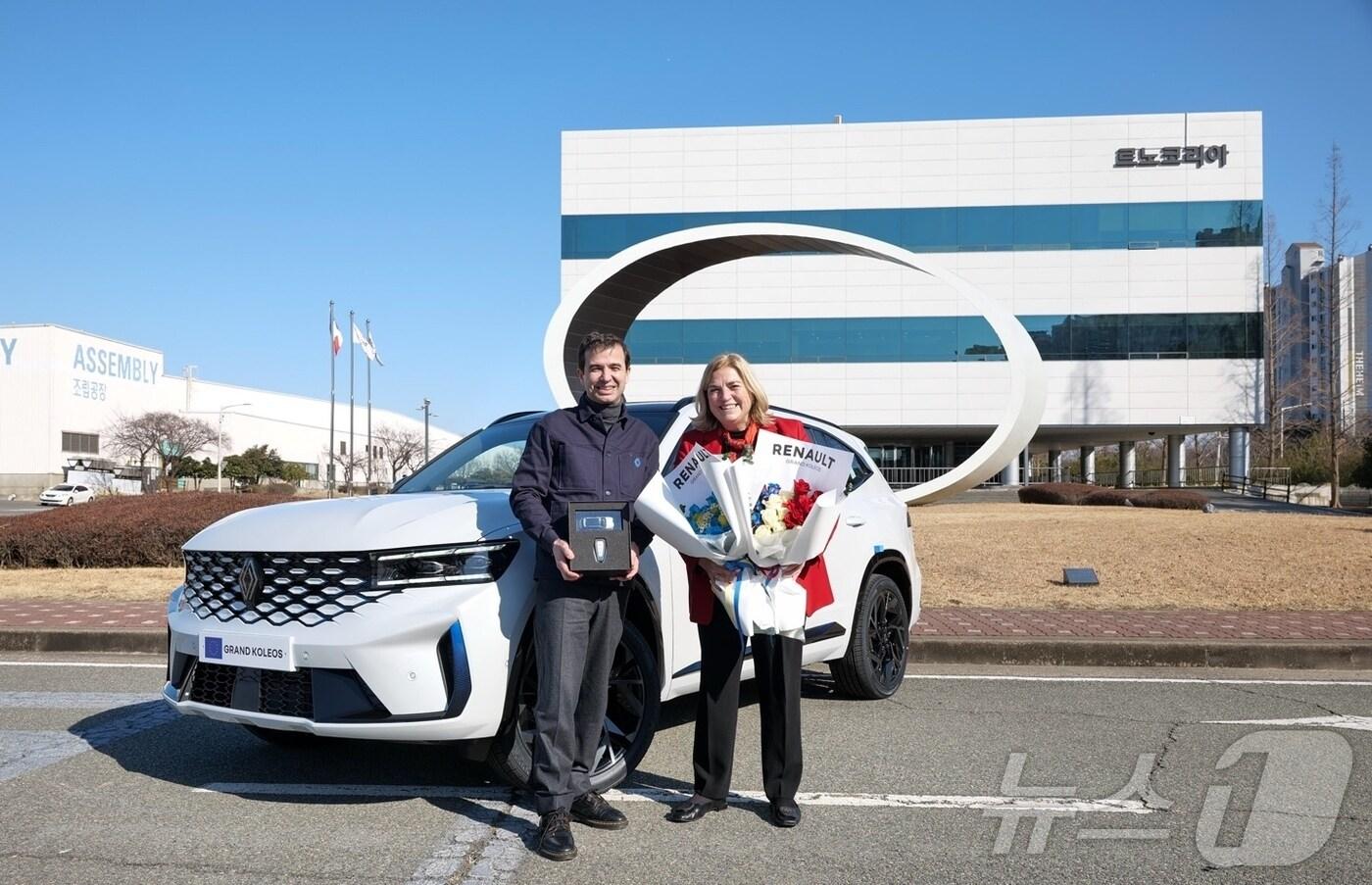 스테판 드블레즈 르노코리아 사장(왼쪽)이 19일 르노코리아 부산공장에서 마리아 카스티요 페르난데즈 주한 EU대사에게 공식차량으로 사용할 그랑 콜레오스 E-Tech 하이브리드를 전달하고 기념 촬영을 하고 있다.르노코리아 제공.재판매 및 DB 금지)