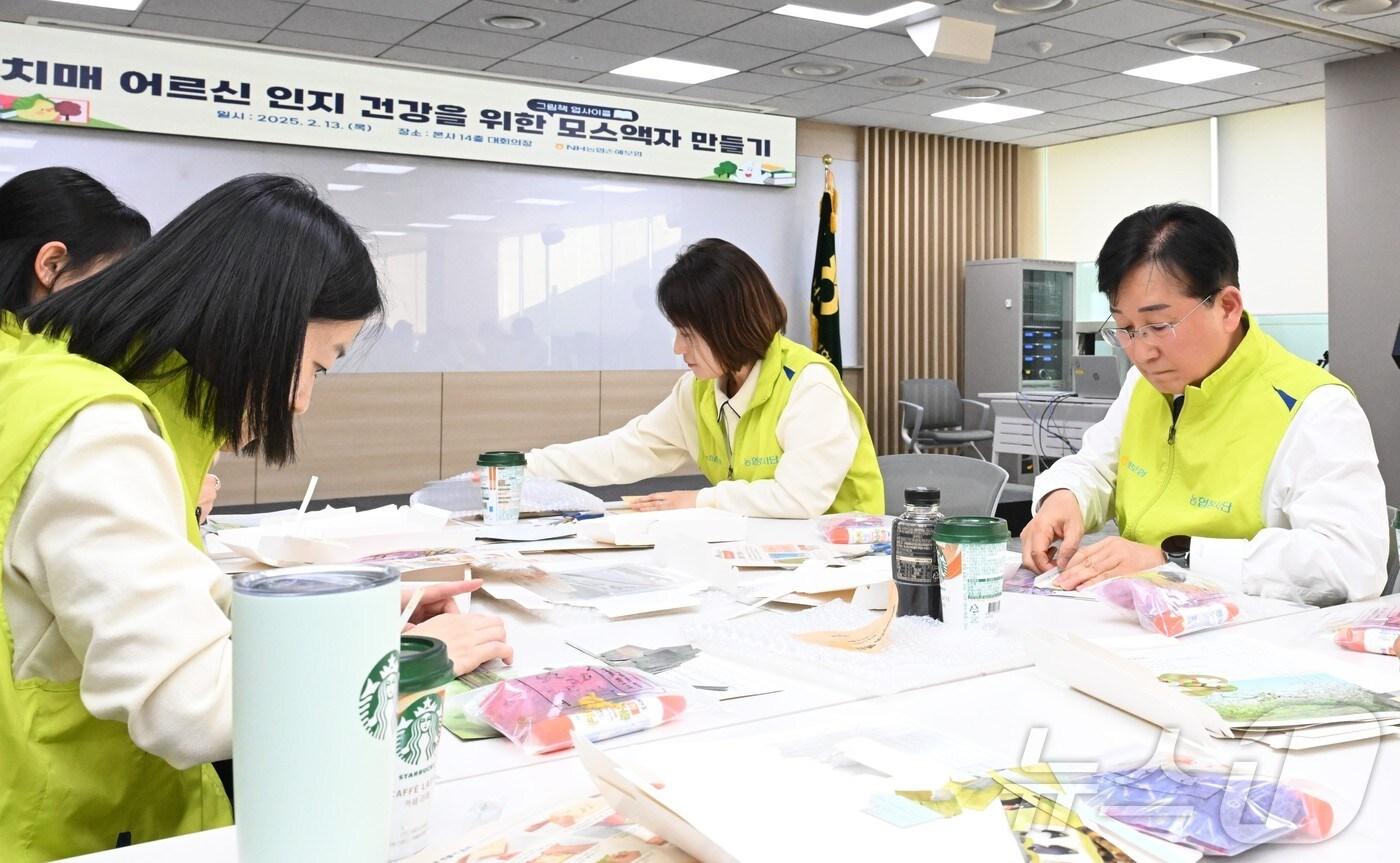 NH농협손해보험은 20일 공기정화액자 300개를 제작해 서울 은평구 치매안심센터에 전달했다고 밝혔다. 송춘수 대표이사를 비롯한 ‘헤아림 봉사단’이 공기정화액자를 만들고 있다./사진제공=농협손보