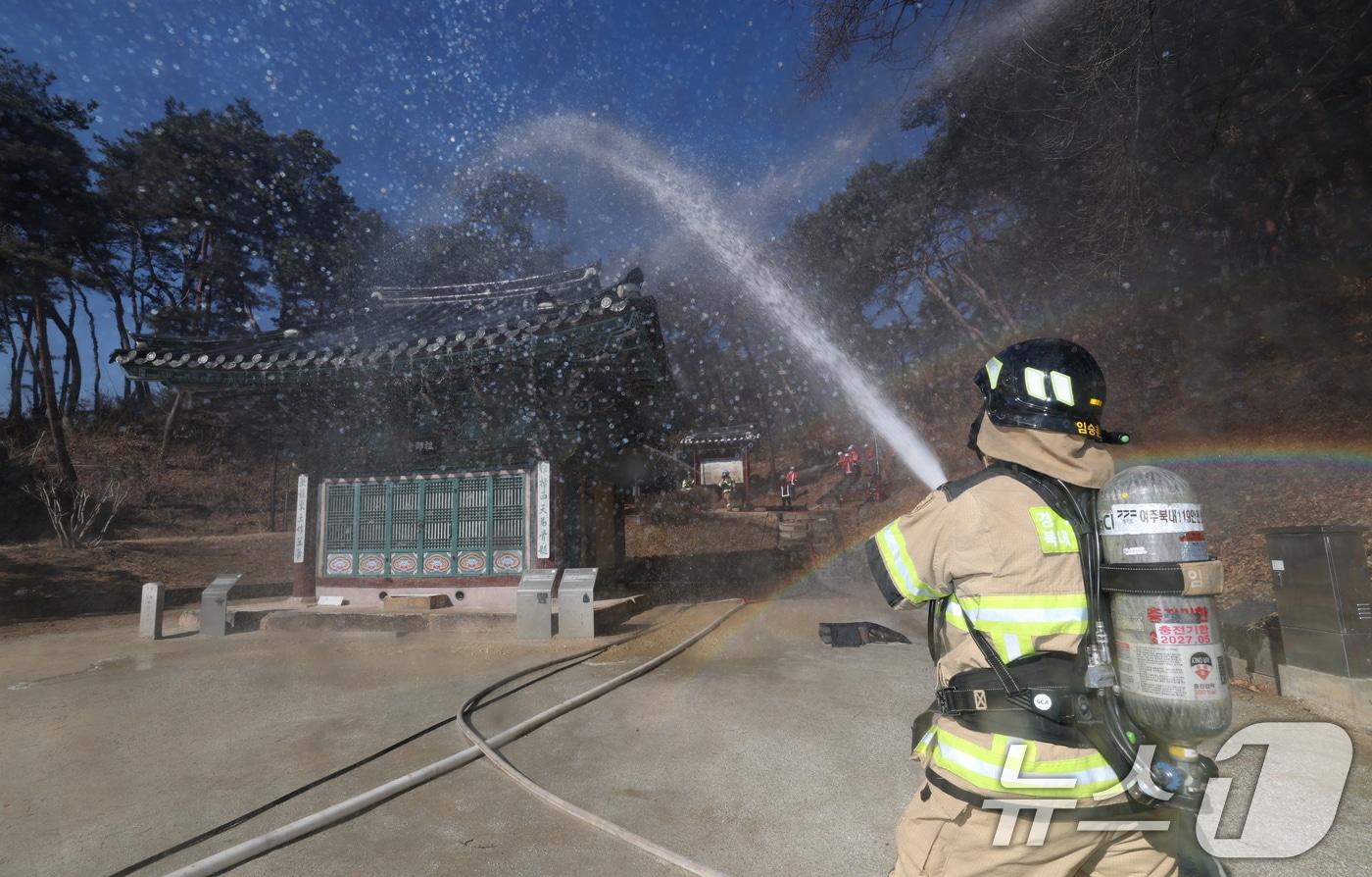 20일 오후 경기 여주시 신륵사에서 열린 '산림화재 대응 및 문화유산 보호·반출 훈련'에서 여주소방서 소방관들이 화재진압 훈련 및 문화재 반출 훈련을 하고 있다. 2025.2.20/뉴스1 ⓒ News1 김영운 기자