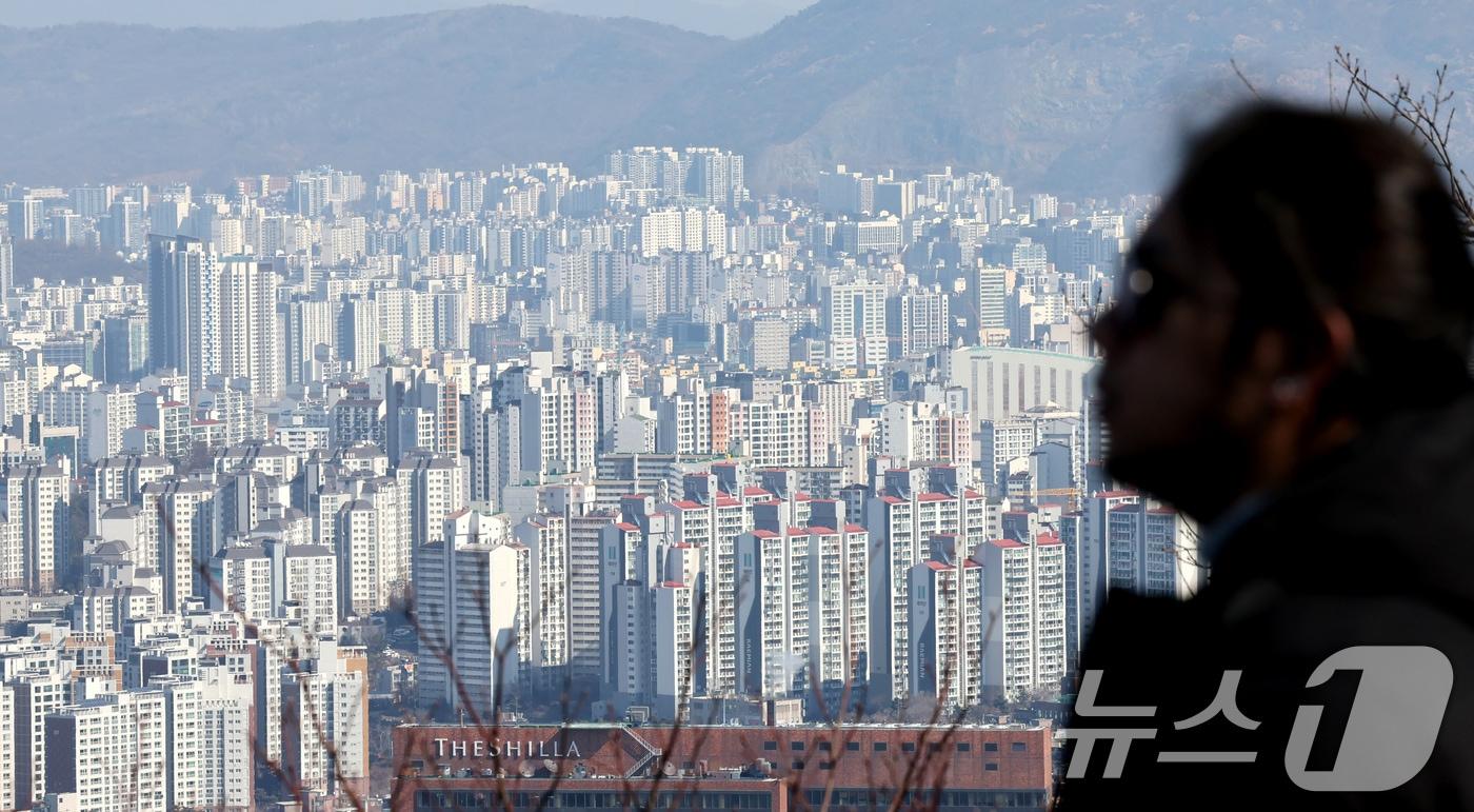 본문 이미지 - 21일 오후 서울 남산을 찾은 관광객이 아파트 단지를 바라보고 있다. 2025.2.21/뉴스1 ⓒ News1 장수영 기자