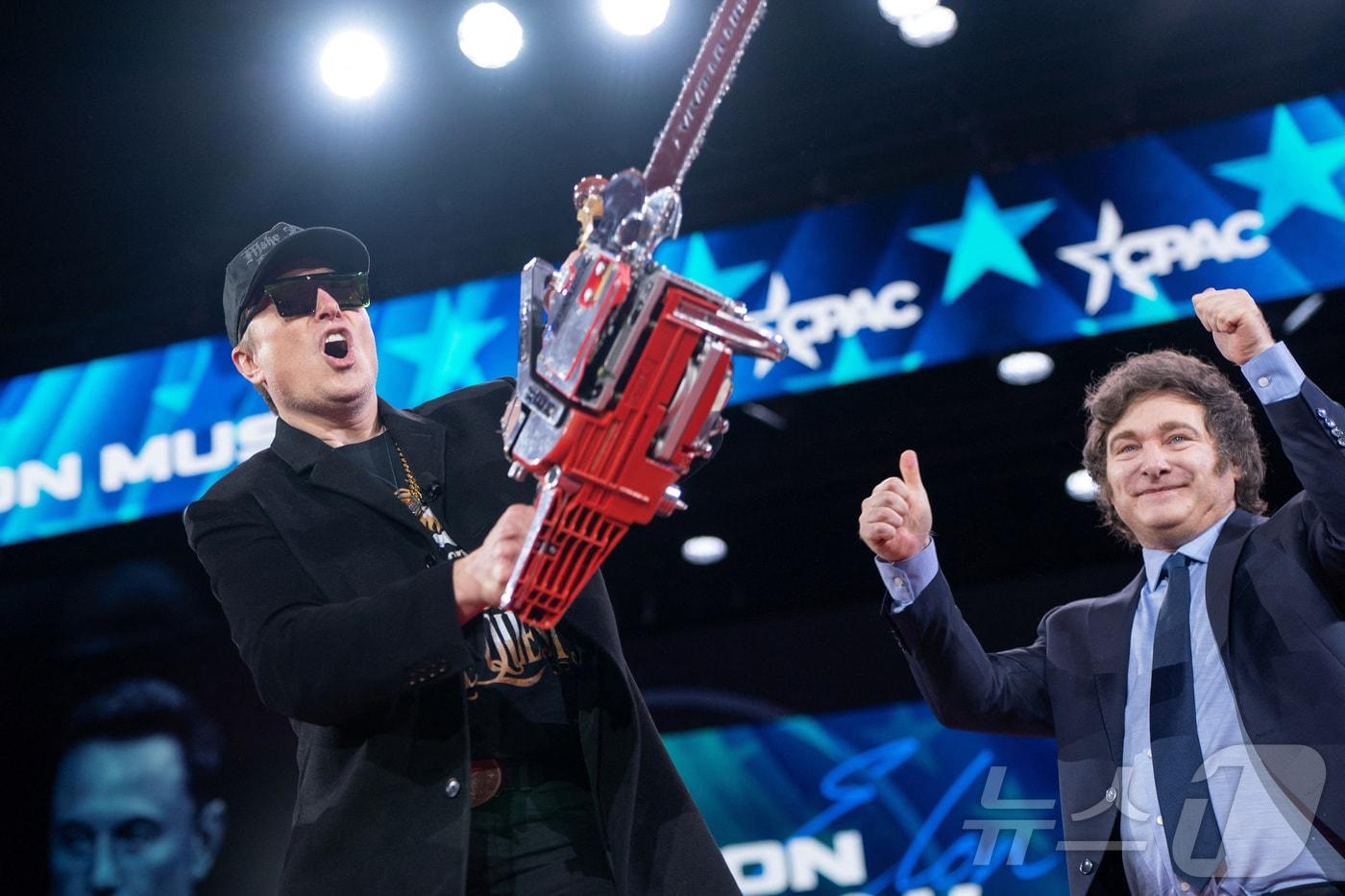 일론 머스크가 2025년 2월 20일 미국 매릴랜드주에서 열린 보수정치행동회의에서 하비에르 밀레이 아르헨티나 대통령에게 받은 전기톱을 높이 들고 있다. ⓒ 로이터=뉴스1