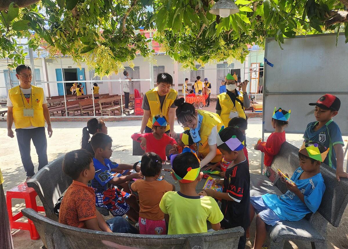 본문 이미지 - CJ그룹이 베트남 닌투언성 땀응마을을 찾아 의료봉사를 한 가운데 CJ제일제당 직원을 비롯한 자원봉사자들이 진료 대기 중인 어린이들을 돌보고 있다.(CJ그룹 제공)