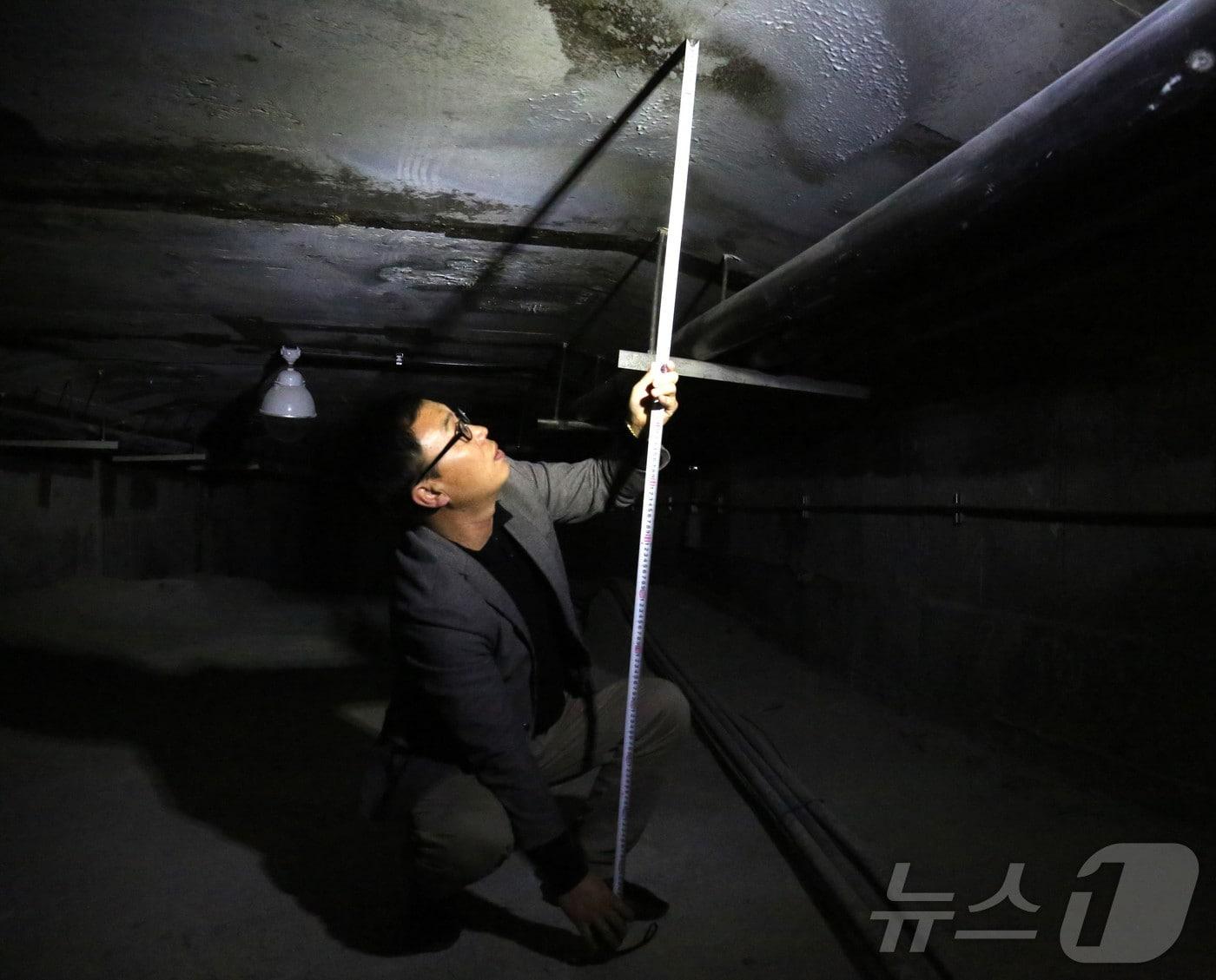 본문 이미지 - 뉴스1 취재진이 제천 옛 청풍대교 속 비밀공간의 크기를 줄자로 재고 있다. 2025.2.25./뉴스1 ⓒ News1 손도언 기자 