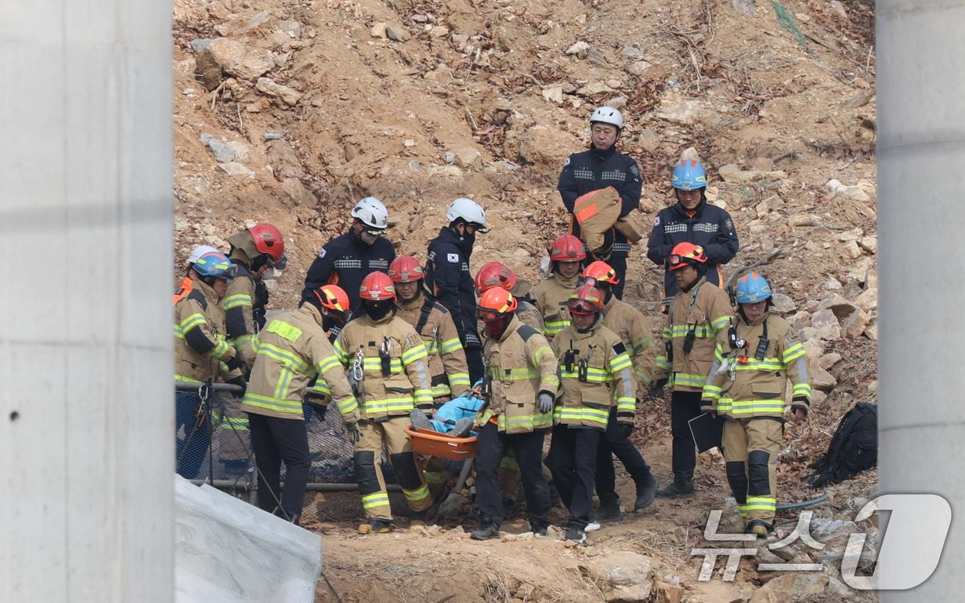 25일 경기 안성시 서운면 산평리 서울-세종고속도로 다리 건설현장에서 철근 구조물이 교각 아래로 떨어져 소방관들이 수색 작업을 마친 뒤 매몰자를 이송하고 있다.2025.2.25/뉴스1 ⓒ News1 김영운 기자