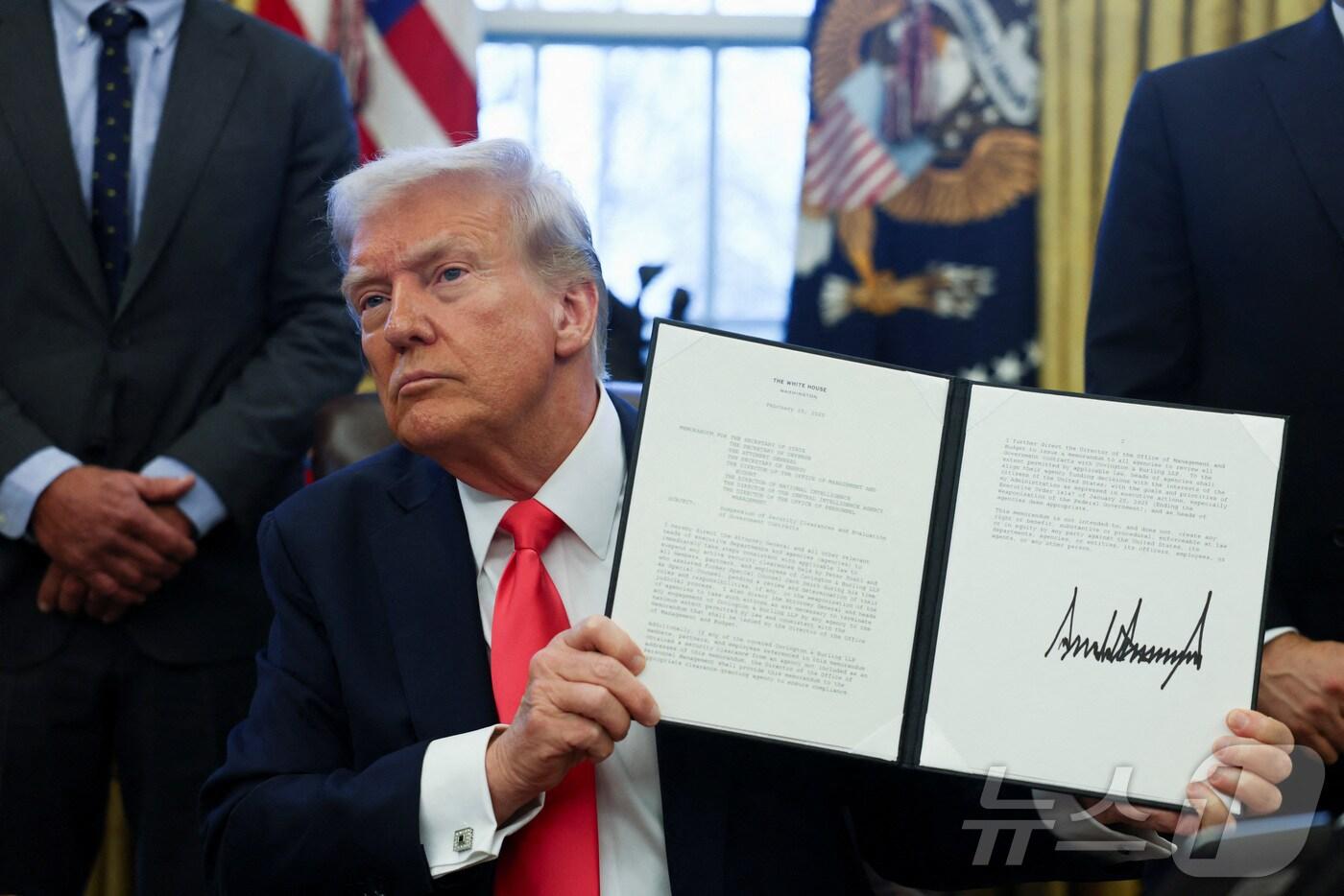 도널드 트럼프 미국 대통령이 25일(현지시간) 미국 워싱턴DC에 있는 백악관 오벌 오피스(대통령 집무실)에서 서명한 행정명령을 들어보이고 있다. ⓒ 로이터=뉴스1 ⓒ News1 류정민 특파원