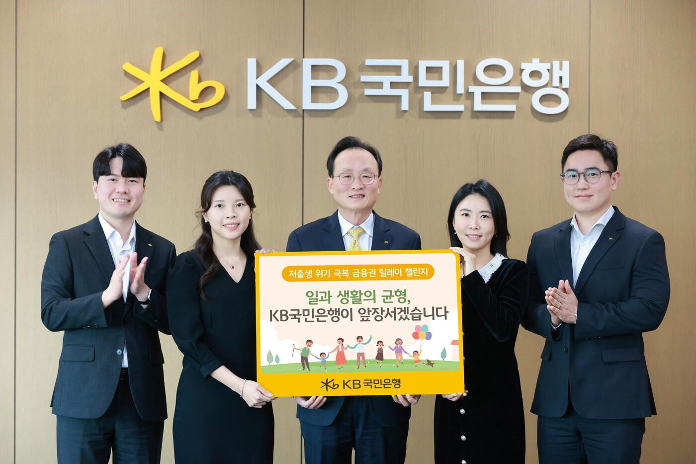 서울시 영등포구에 위치한 KB국민은행 신관에서 이환주 KB국민은행장(가운데)과 ‘KB아이사랑적금’를 기획한 KB국민은행 수신상품부 직원들이 '저출생 위기 극복 챌린지'에 참여해 기념 촬영을 하고 있다. (KB국민은행 제공)