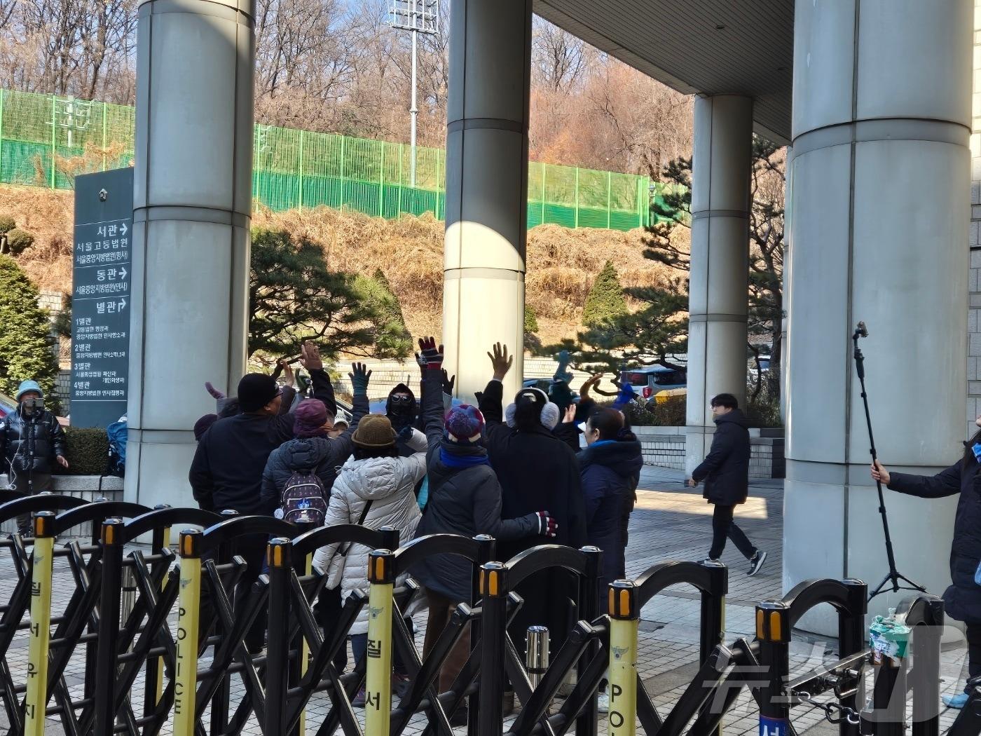 본문 이미지 - 25일 오전 서울 서초구 서울중앙지법 서관 인근에서 이재명 더불어민주당 대표 지지자들이 동그랗게 모여 '이재명'을 연호하고 있다. 2025.2.26/뉴스1 ⓒ News1 남해인 기자