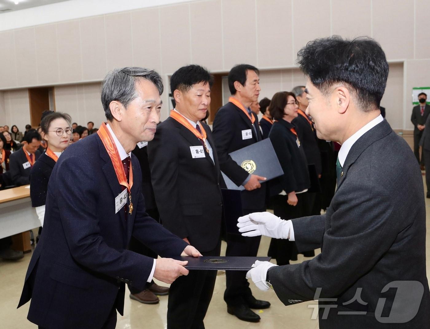 본문 이미지 - 김대중 전남교육감이 퇴직교원에게 훈·포장을 전수하고 있다.&#40;전남교육청 제공&#41;/뉴스1 
