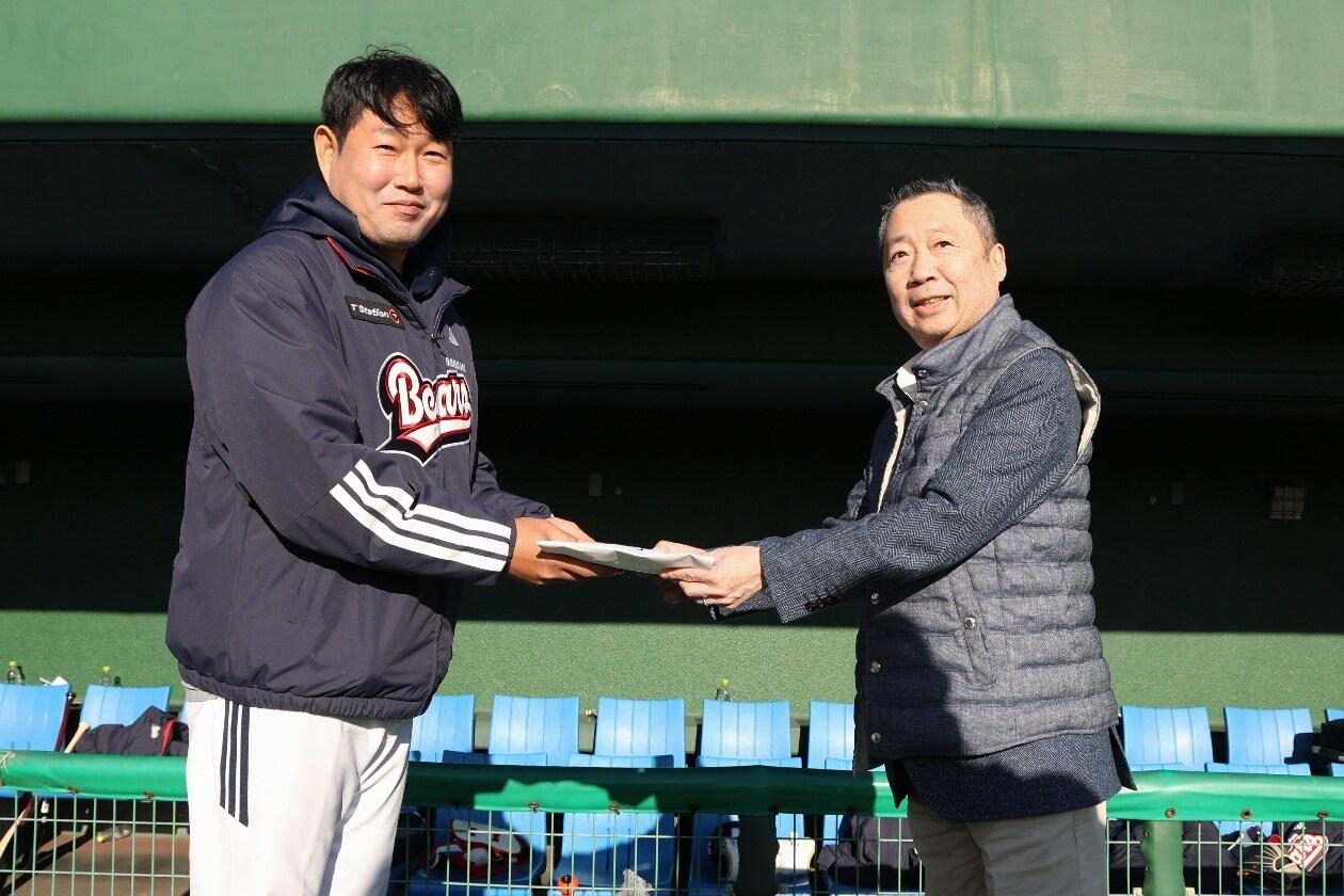 본문 이미지 - 두산 스프링캠프를 찾은 박정원 구단주(오른쪽)가 주장 양의지에게 격려금을 전달하고 있다.(두산 베어스 제공)