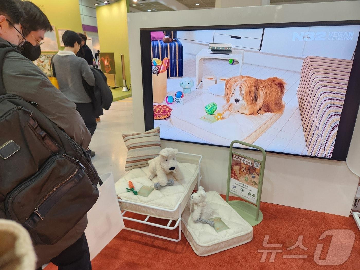 본문 이미지 - 27일 서울 코엑스에서 열린 서울리빙디자인페어에서 시몬스의 멀티 브랜드 N32에서 출시한 반려동물용 매트리스 '쪼꼬미'를 관람객이 구경하고 있다. ⓒ 뉴스1 한송아 기자