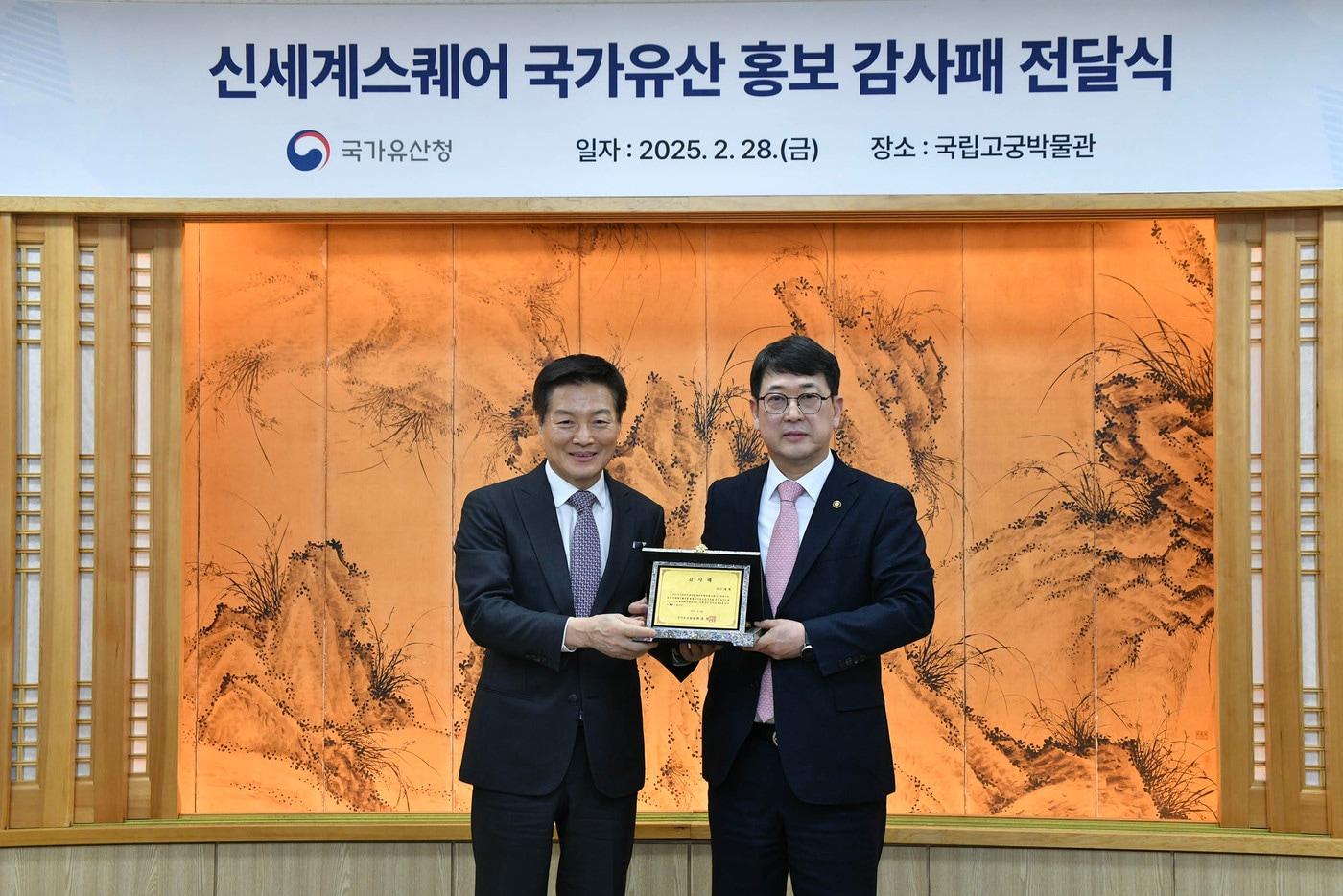 ㈜신세계 박주형 대표이사가 최응천 국가유산청장으로부터 감사패를 받은 뒤 기념 사진을 찍고 있다.(신세계 제공).