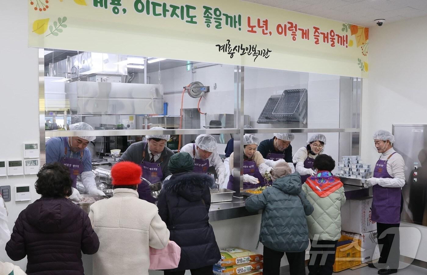 본문 이미지 - 계룡시의회 의원들이 ‘어르신 행복식당’에서 배식 봉사를 하고 있다. (계룡시의회 제공) /뉴스1