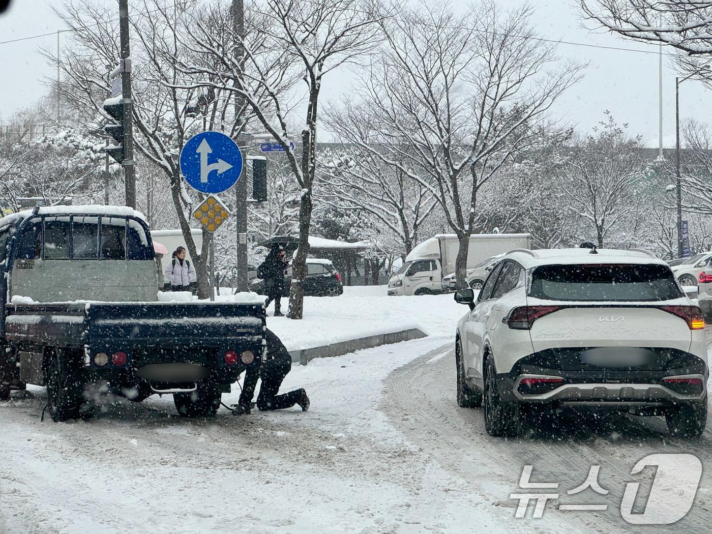 본문 이미지 - 4일 삼성화재 교통안전문화연구소는 &#39;동절기 수도권 미끄럼 교통사고 분석결과&#39;를 발표했다. 사진은 광주 광산구 한 도로에서 빙판길에 빠진 1톤 트럭 차주가 밧줄로 뒷바퀴를 고정시키고 있다. 2025.2.4/뉴스1 ⓒ News1 이승현 기자