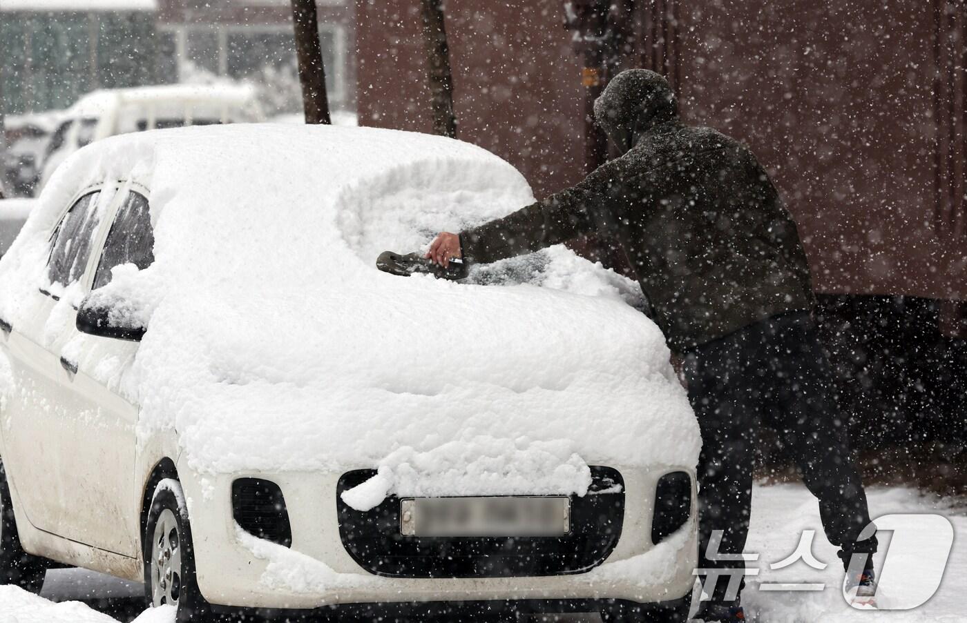 많은 눈이 내린 4일 오전 광주 광산구 한 아파트에서 시민이 차에 쌓인 눈을 치우고 있다. 2025.2.4./뉴스1 ⓒ News1 김태성 기자