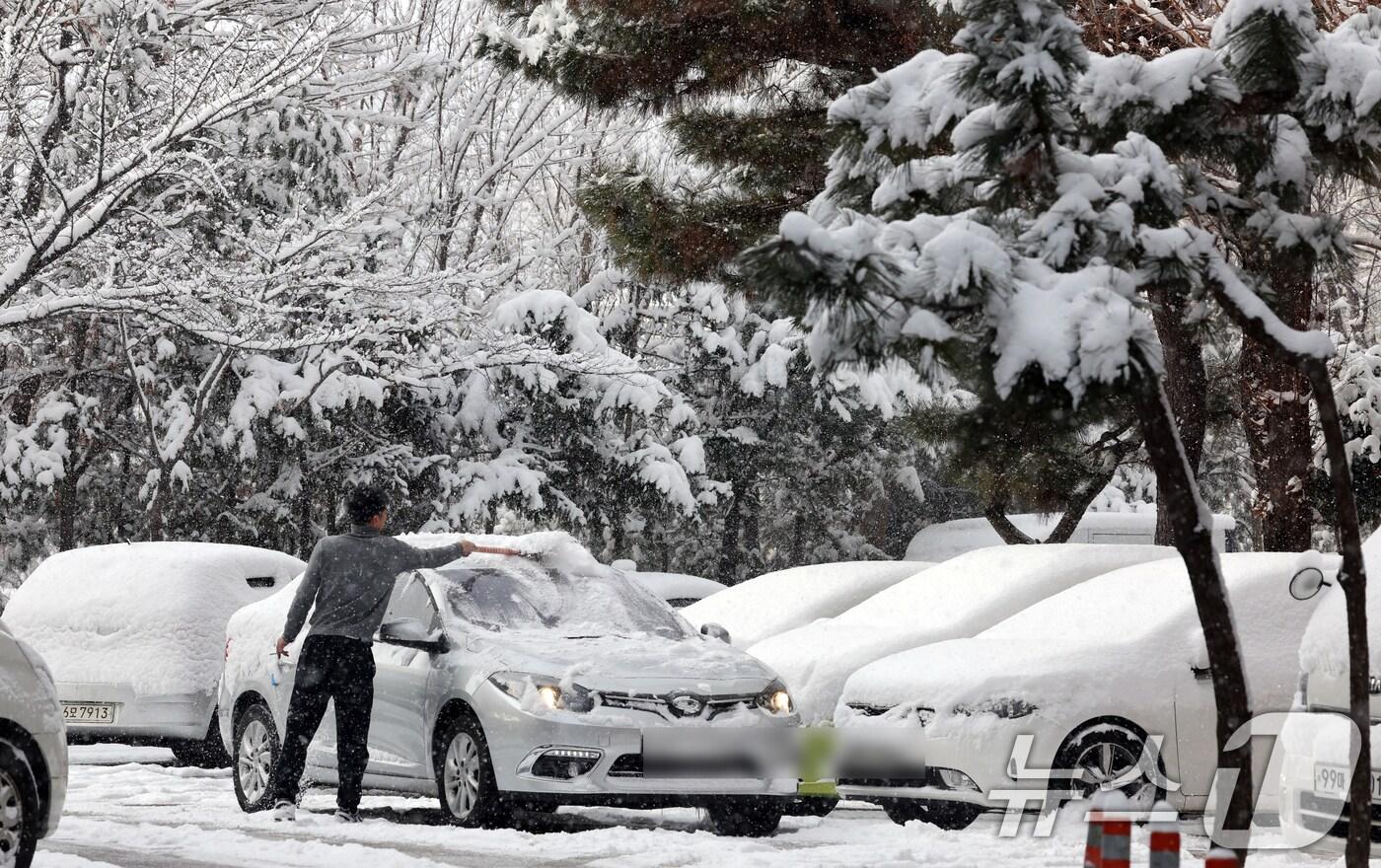 광주 광산구 한 아파트에서 한 시민이 차에 쌓인 눈을 치우고 있다. /뉴스1 ⓒ News1 김태성 기자