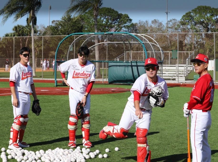 본문 이미지 -  SSG 랜더스 1차 스프링캠프지 미국 플로리다에서 훈련 중인 포수 이율예, 조형우, 신범수(왼쪽부터). 이들의 옆으로 세리자와 유지 배터리 코치가 매서운 눈으로 훈련을 지도하고 있다. (SSG 랜더스 제공)