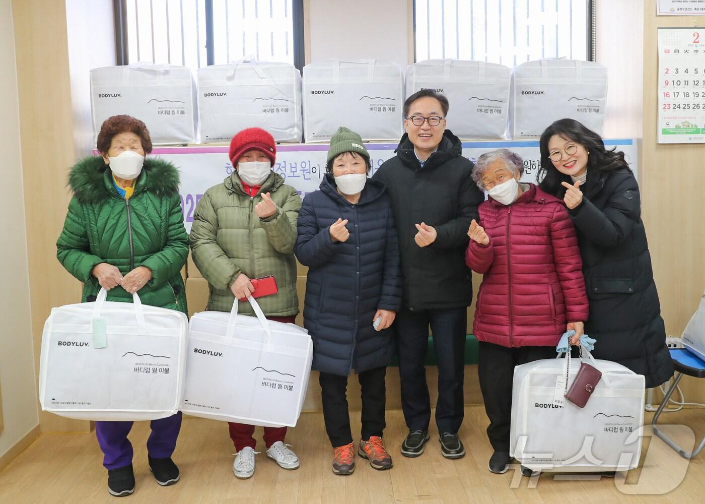 본문 이미지 - 유성훈 금천구청장(사진 왼쪽 네 번째)이 주민들에게 겨울이불을 전달하고 기념사진을 찍고 있다. (금천구청 제공)