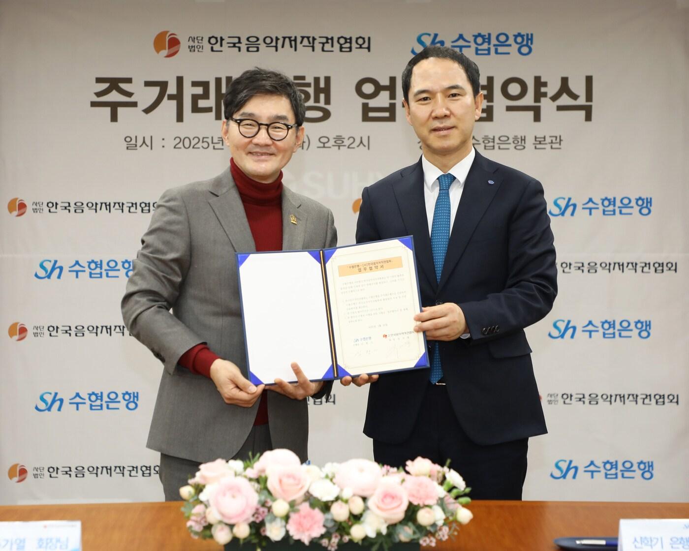 본문 이미지 - 주거래은행 업무협약식에서 Sh수협은행 신학기 은행장(오른쪽)과 한국음악저작권협회 추가열 회장이 협약서에 서명한 후 기념촬영을 하는 모습 (Sh수협은행 제공)
