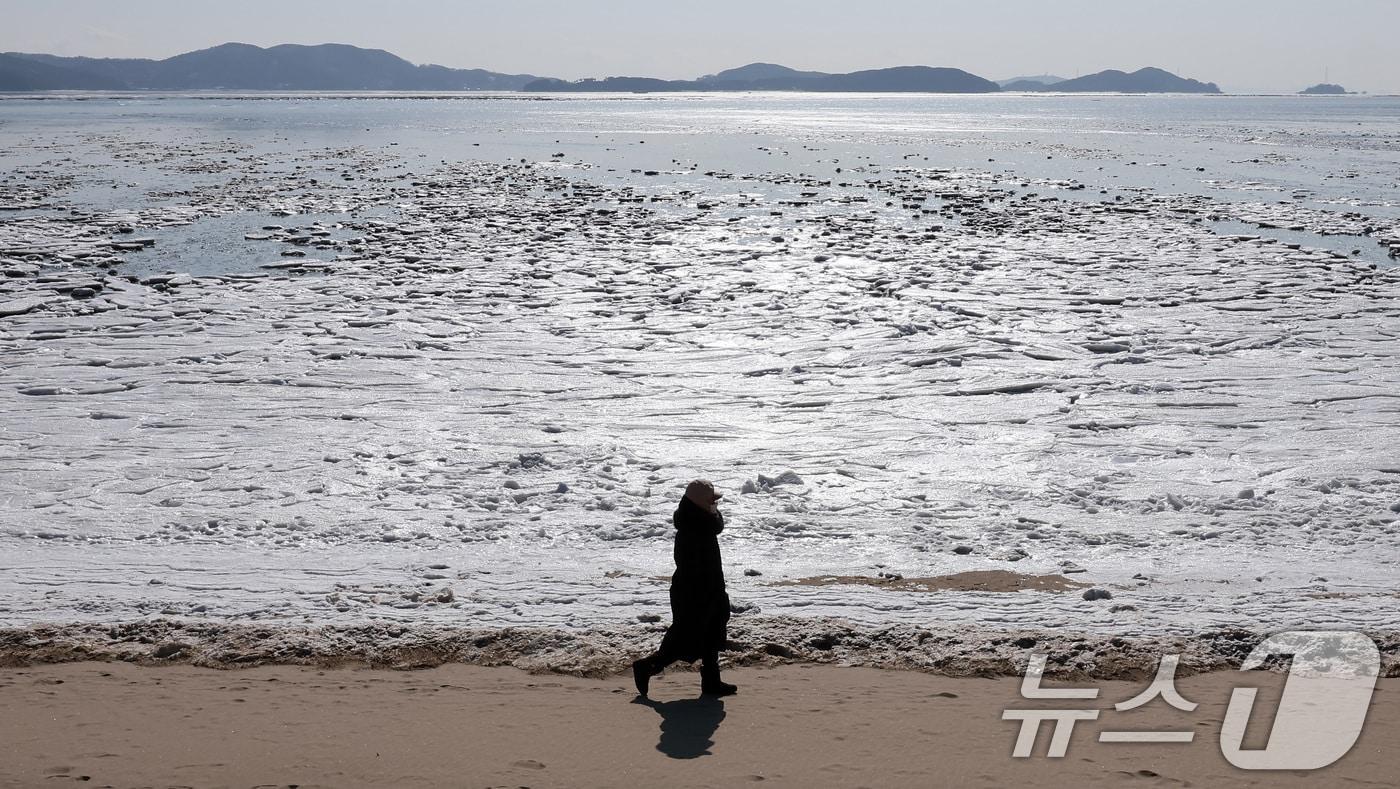 전국 대부분에 한파특보가 발효된 5일 인천 강화도 동막해변에서 한 시민이 얼어버린 갯벌을 보며 산책하고 있다. 기상청은 이날 전국 대부분 지역에서 출근길 -10도 이하의 기온을 보이며 당분간 강추위가 이어질 것이라고 예보했다. 2025.2.5/뉴스1 ⓒ News1 김성진 기자