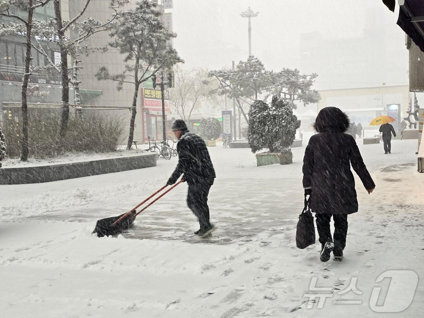 본문 이미지 - 6일 오후 경기 고양 덕양구 화정역 인근에 많은 눈이 내린 가운데 시민들이 점포 앞에 쌓인 눈을 치우고 있다. 2025.2.6/뉴스1 ⓒ News1 황덕현 기후환경전문기자