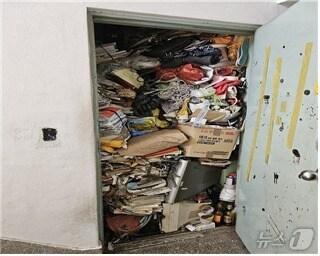 본문 이미지 - 지난달 이웃주민의 신고로 구조된 김 모씨 집 현관문에 쓰레기 더미가 쌓여 있다.(남구 제공)