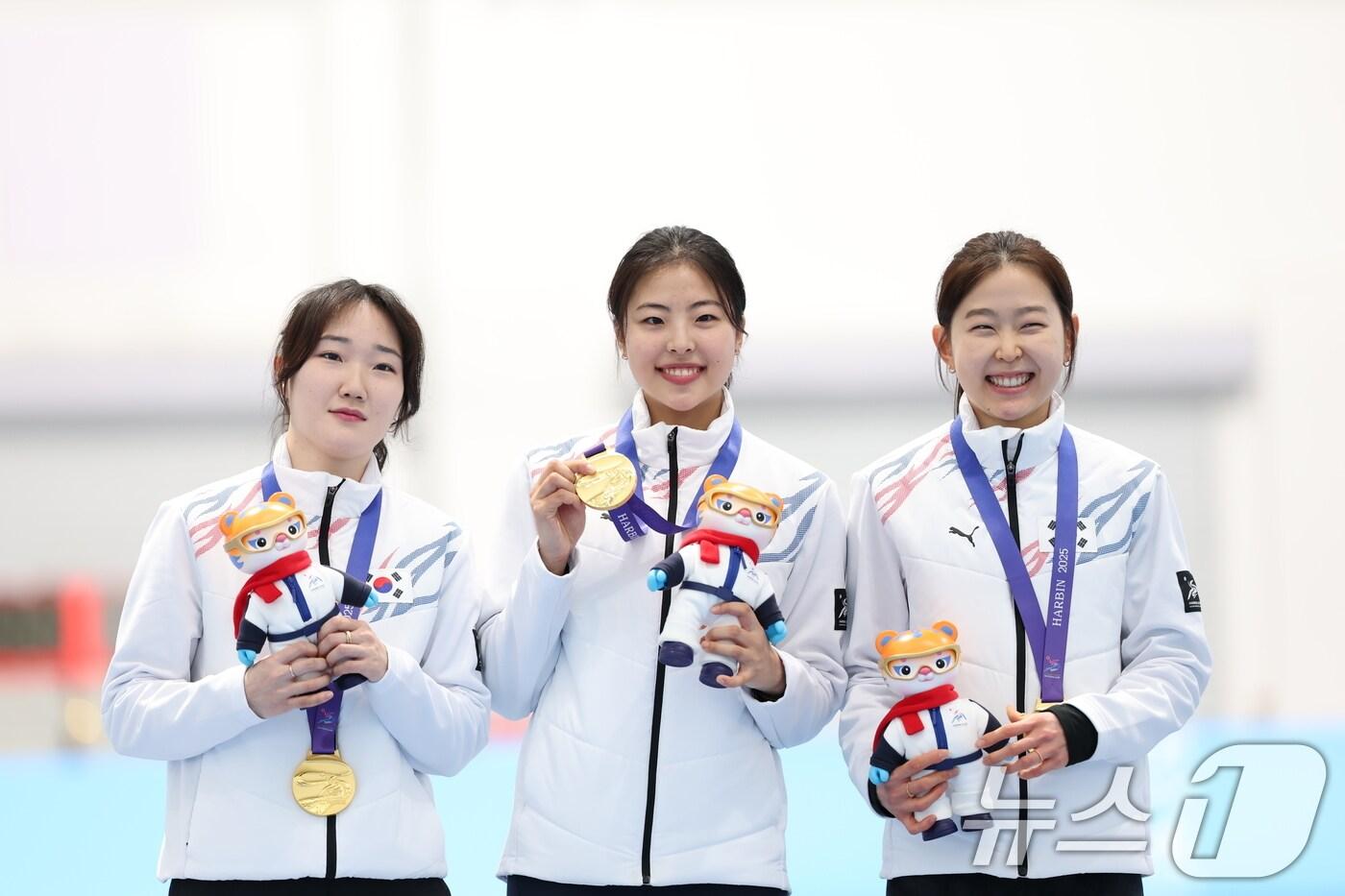 본문 이미지 - 9일(현지시간) 중국 헤이룽장성 하얼빈 스피드 스케이트 오벌에서 열린 하얼빈 동계아시안게임 스피드 스케이팅 여자 팀스프린트 시상식에서 김민지(왼쪽부터), 이나현, 김민선이 금메달을 들어보이고 있다. 대표팀은 이날 1분 28초 62로 금메달을 획득했다. 2025.2.9/뉴스1 ⓒ News1 이승배 기자