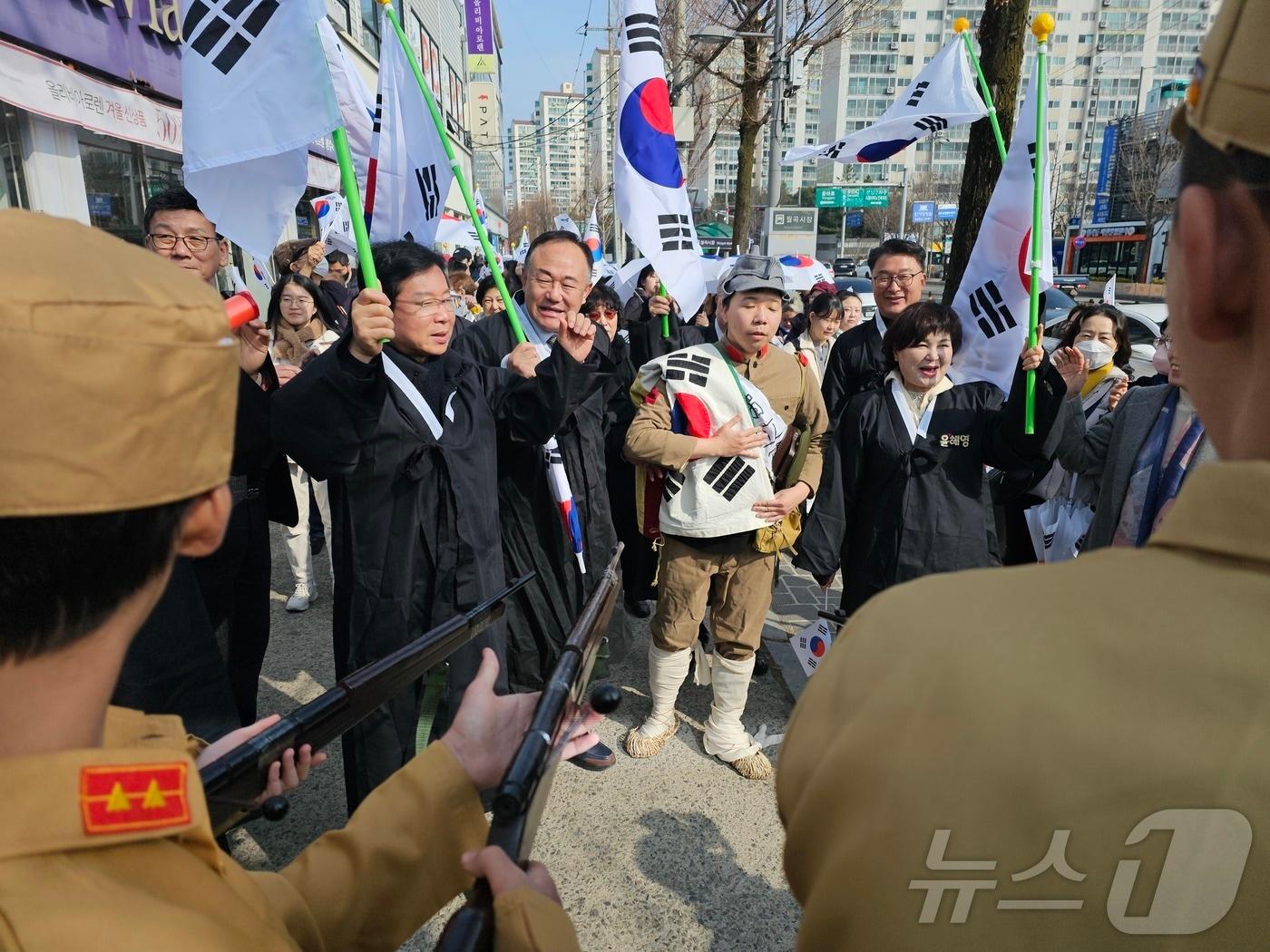 본문 이미지 - 1일 광주 광산구 월곡동에서 열린 106주년 삼일절 및 연해주 고려인만세운동 행사에 참여한 박병규 광산구청장 등 독립운동가로 분장한 참가자들이 순사복장을 한 이들과 대치하는 모습을 연출하고 있다.2025.3.1./뉴스1 ⓒ News1 서충섭 기자