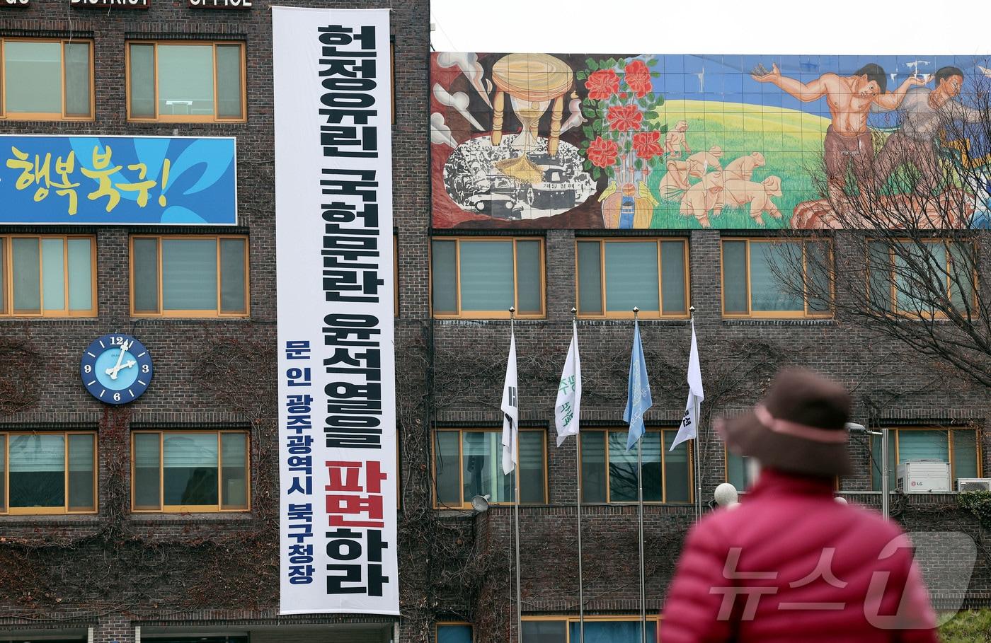 10일 오후 광주 북구청사 건물 외벽에는 &#39;헌정유린 국헌문란 윤석열을 파면하라&#39;는 내용의 대형 현수막이 부착돼 시민들이 이를 바라보고 있다.&#40;광주 북구 제공. 재판매 및 DB금지&#41;2025.3.10/뉴스1