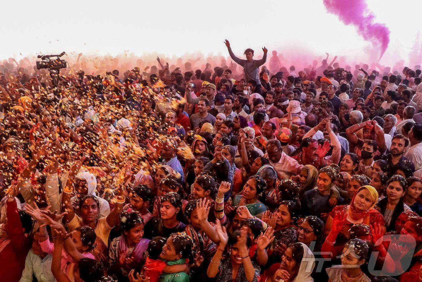 10일(현지시간) 인도 북부 우타르프라데시주 마투라에서 열린 힌두교의 봄 축제 홀리 기간에 신자들이 꽃과 색 가루인 '굴랄'을 뿌리고 있다. ⓒ AFP=뉴스1