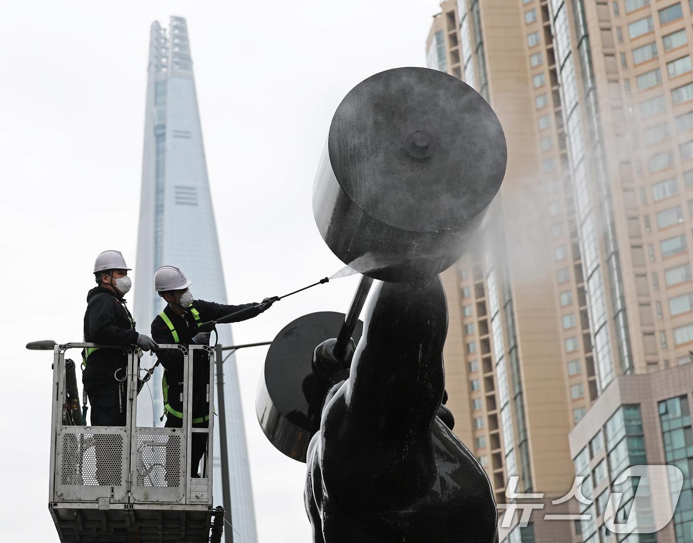 본문 이미지 - 송파구 관계자들이 12일 서울 송파구 올림픽로에 설치된 올림픽 상징 역도 조형물을 고압 세척기를 이용해 물 청소를 하고 있다. 송파구는 봄을 맞아 오는 14일까지 잠실종합운동장부터 5.6km 구간에 걸쳐 황사 및 미세먼지, 매연 등으로 오염된 올림픽 상징 조형물의 묵은 때를 제거하고 안전 점검을 실시한다. 2025.3.12/뉴스1 ⓒ News1 오대일 기자