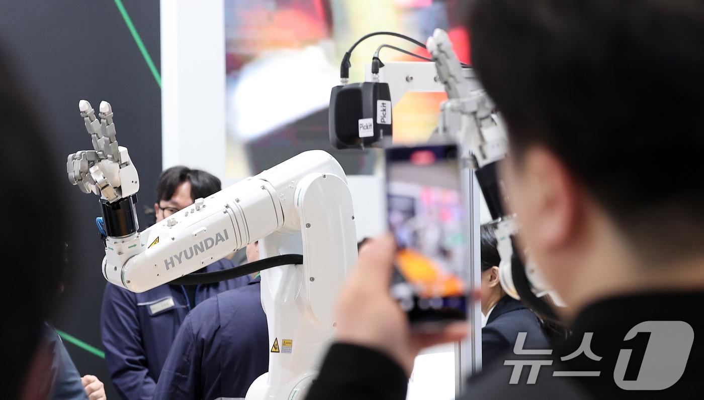 12일 서울 강남구 코엑스에서 열린 2025 스마트공장·자동화산업전를 찾은 관람객들이 HD현대로보틱스 부스에서 시연을 관전하고 있다. 2025.3.12/뉴스1 ⓒ News1 김성진 기자
