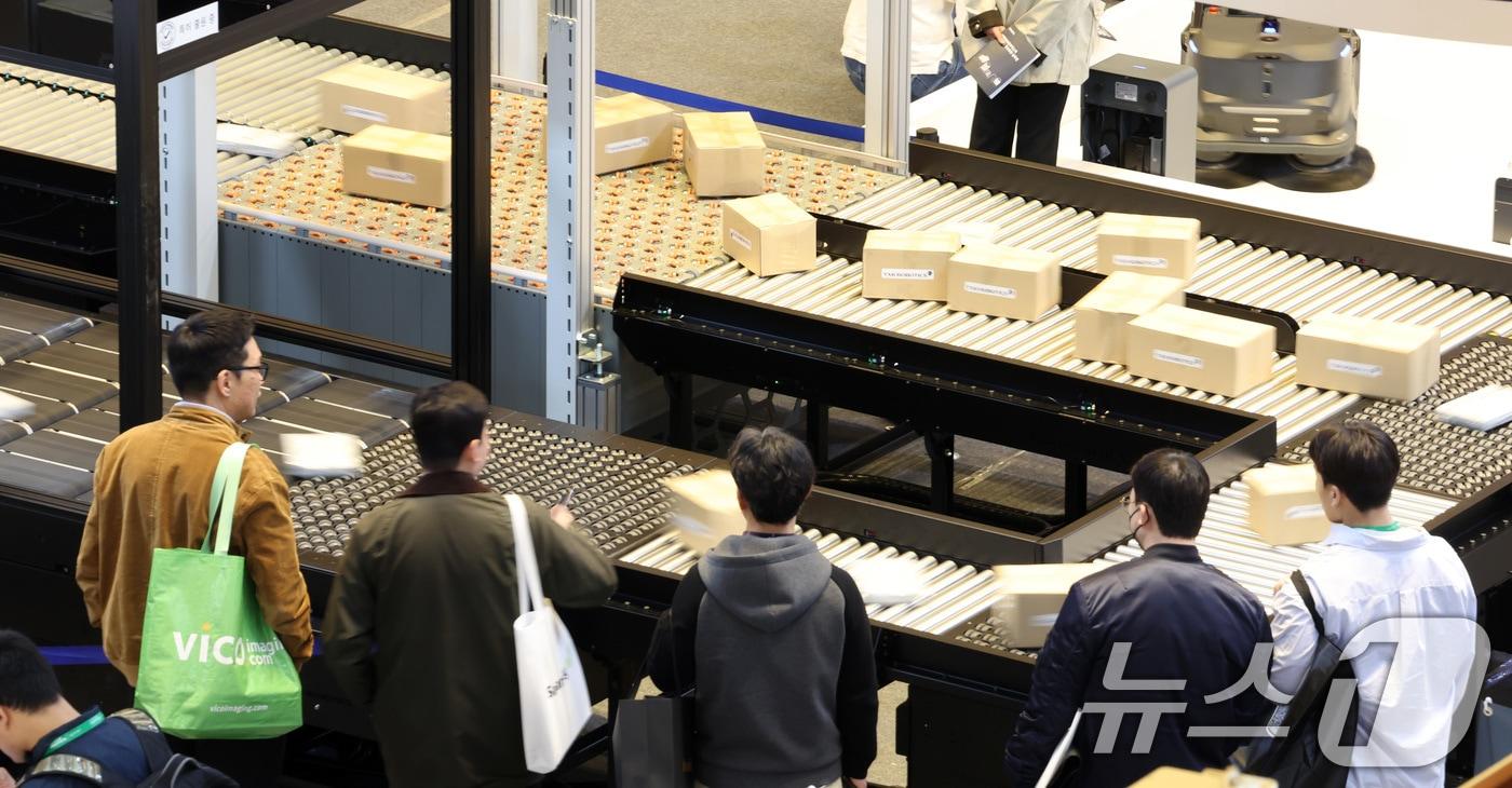 본문 이미지 - 2025 스마트공장·자동화산업전를 찾은 관람객들이 물류 자동화 시스템 시연을 관전하고 있다. 기사 내용과 관련 없음./뉴스1 ⓒ News1 김성진 기자
