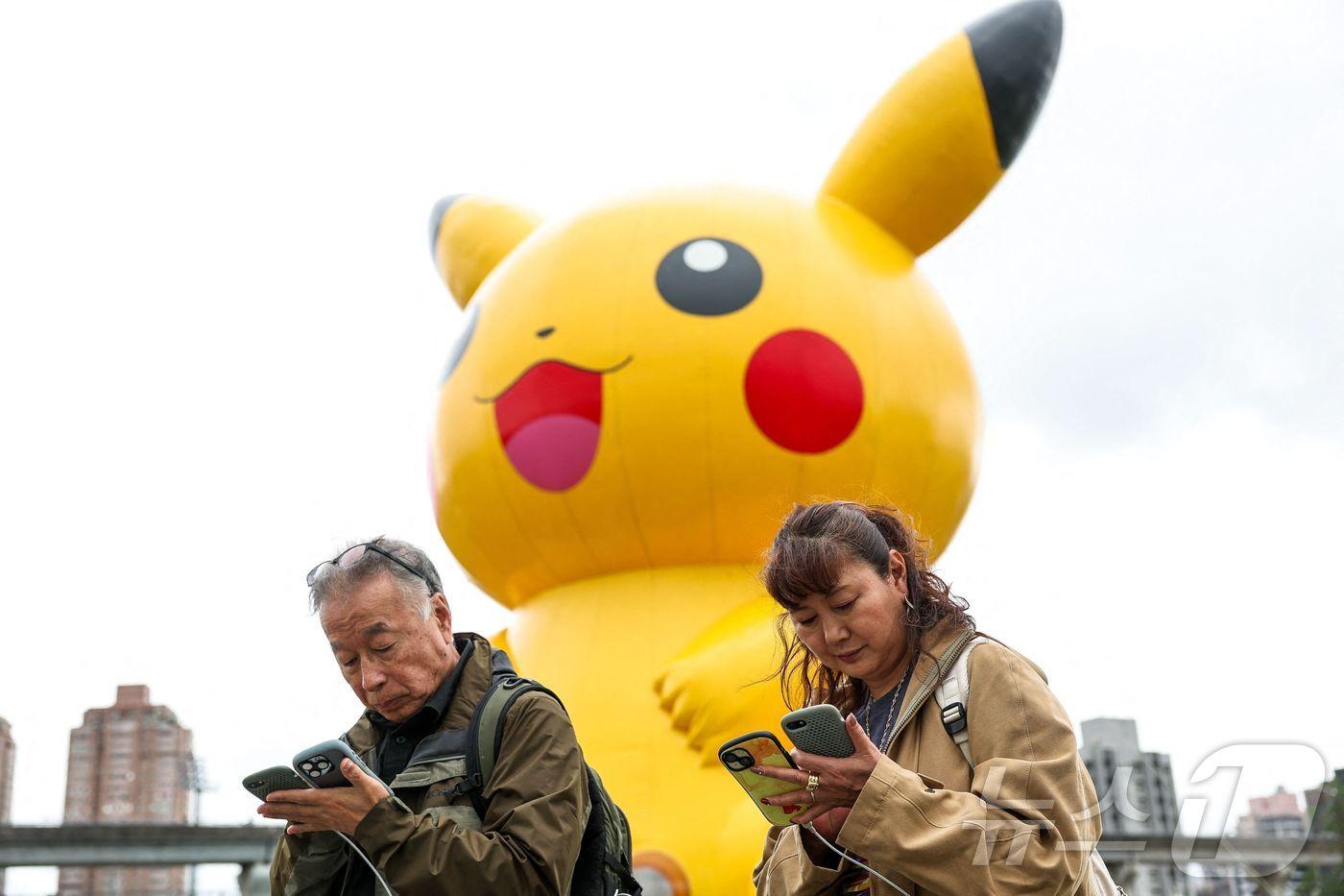 대만에서 열린 포켓몬고 투어 개막일에 시민들이 스파트폰으로 포켓몬 고를 하고 있다. 2025.02.21. ⓒ AFP=뉴스1
