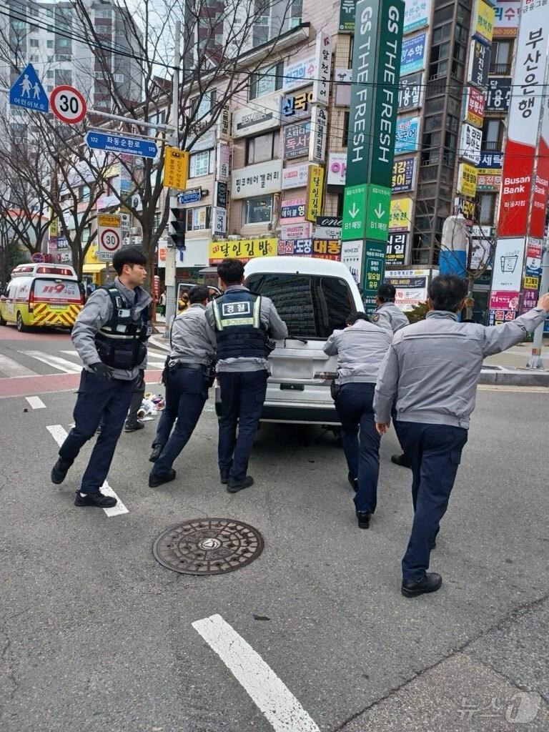 본문 이미지 - 부산 해운대경찰서 좌동지구대 순찰1팀이 전도된 승합차를 세운 뒤 안전한 곳으로 이동시키고 있다.(해운대경찰서 제공. 재판매 및 DB 금지)