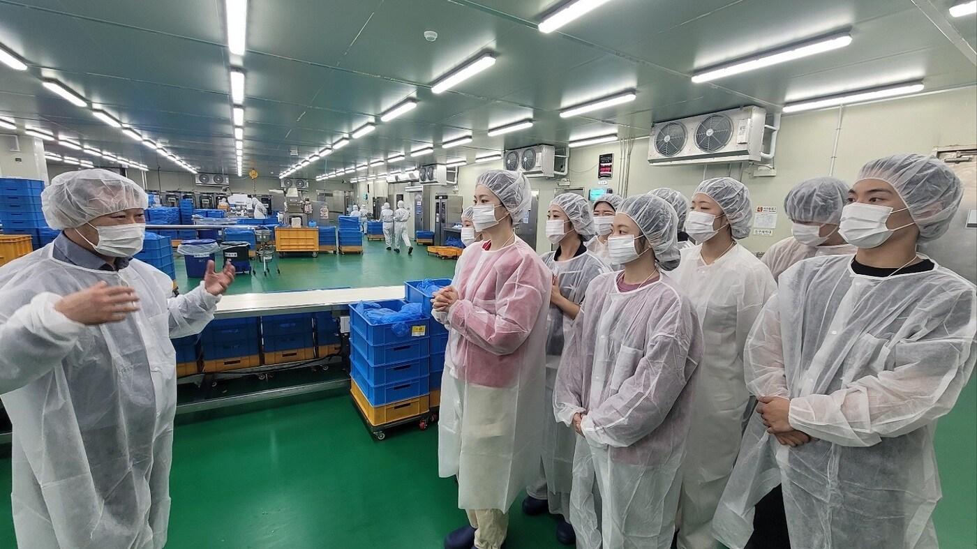 지난 14일 이마트24 FF공장에서 대학생 MD서포터즈가 공장장의 설명을 듣고 있다.(이마트24 제공)