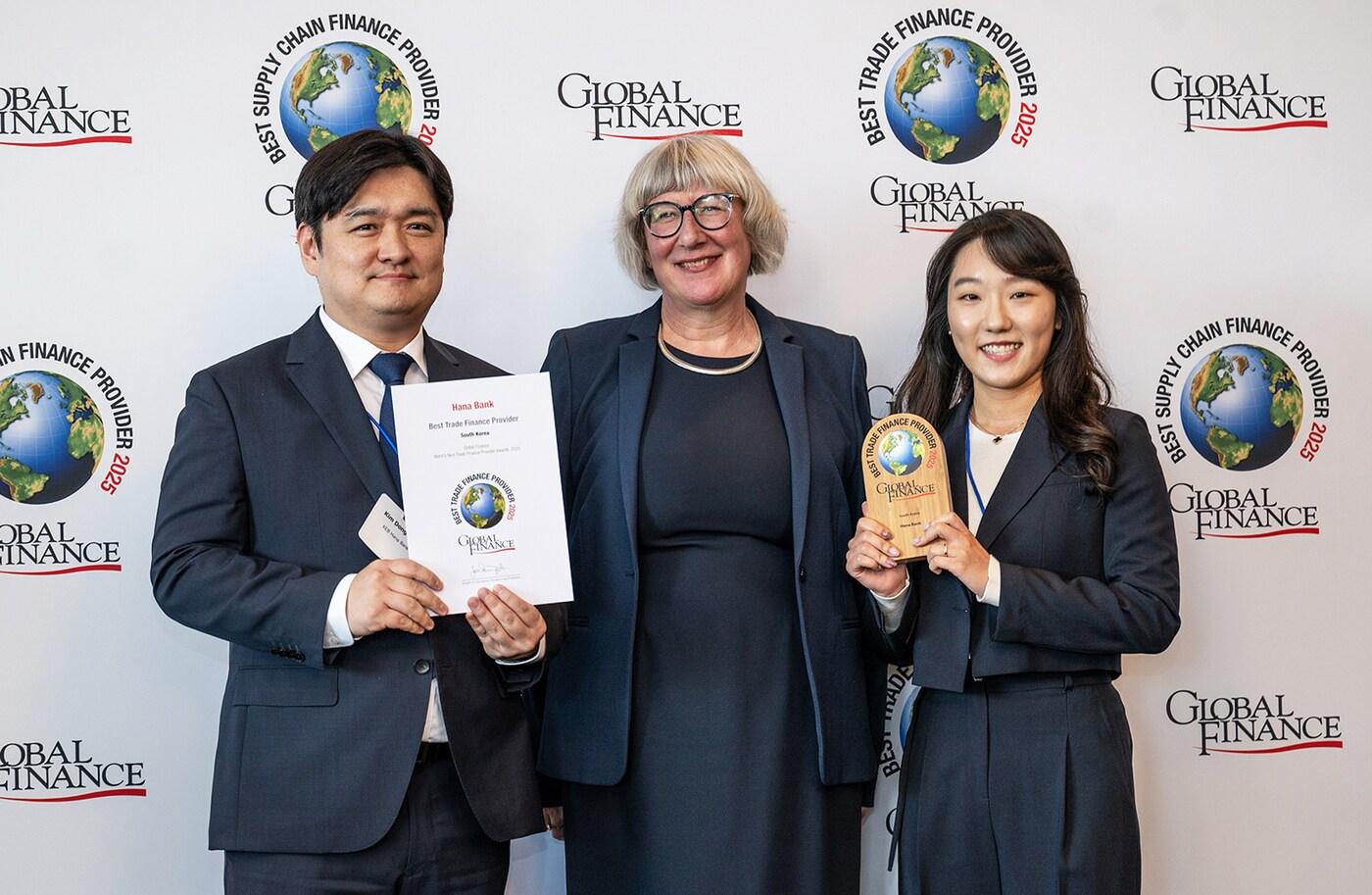 본문 이미지 - 하나은행은 미국 글로벌 금융·경제 전문지 '글로벌파이낸스'가 선정하는 '2025 대한민국 최우수 무역금융 은행(Best Trade Finance Provider in Korea 2025)'상을 수상했다. 이날 시상식에 참석한 김동혁 가산디지털금융센터지점 팀장(사진 왼쪽)이 길리 라이트(Gilly Wright) 글로벌파이낸스誌 트랜잭션 뱅킹 에디터(사진 가운데)와 기념 촬영을 하고 있다. (하나은행 제공)