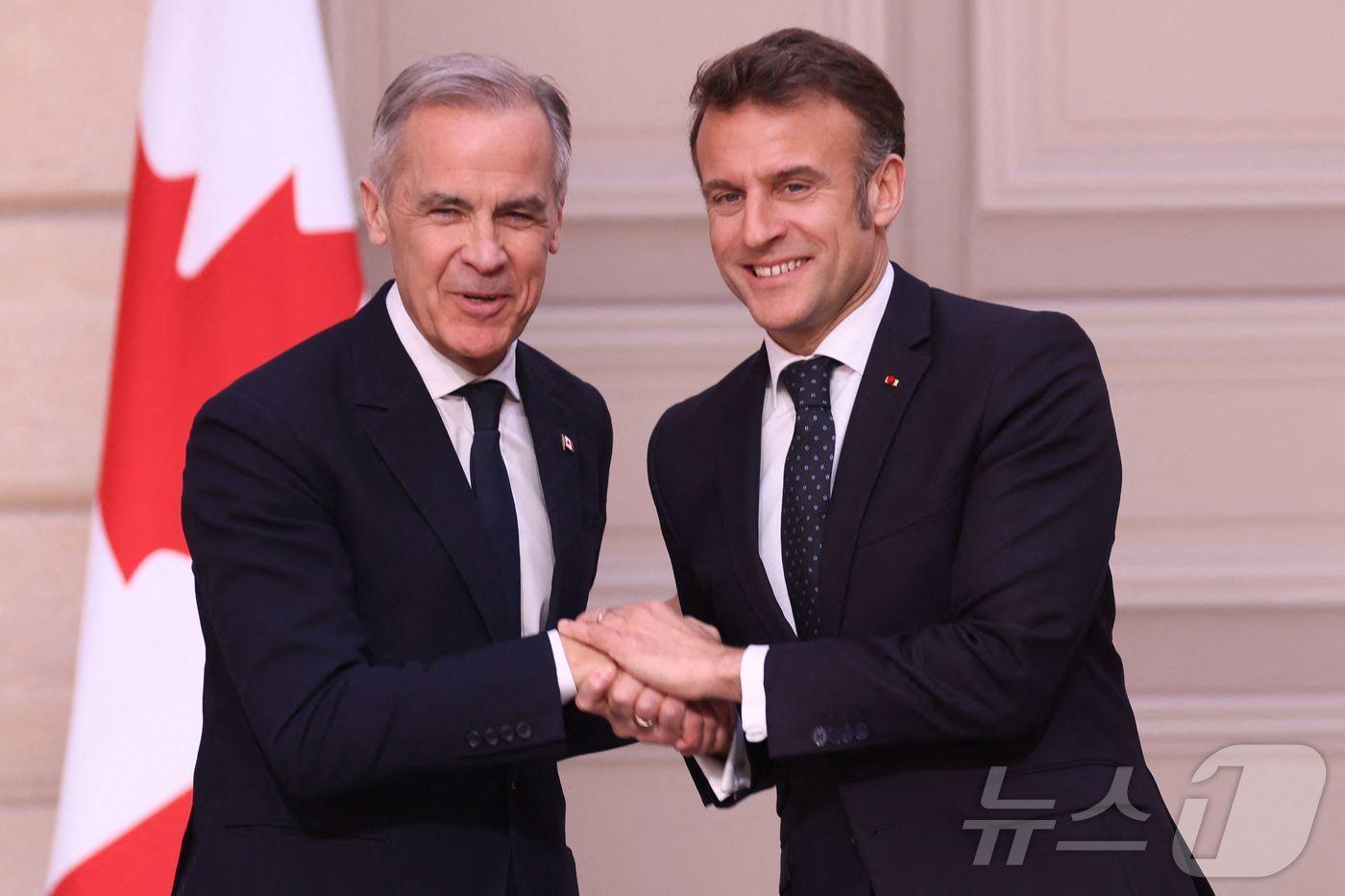 마크 카니 캐나다 신임 총리(왼쪽)가 17일(현지시간) 에마뉘엘 마크롱 프랑스 대통령과 엘리제궁에서 공동 기자회견 후 손을 맞잡았다. 2025.03.17.ⓒ AFP=뉴스1
