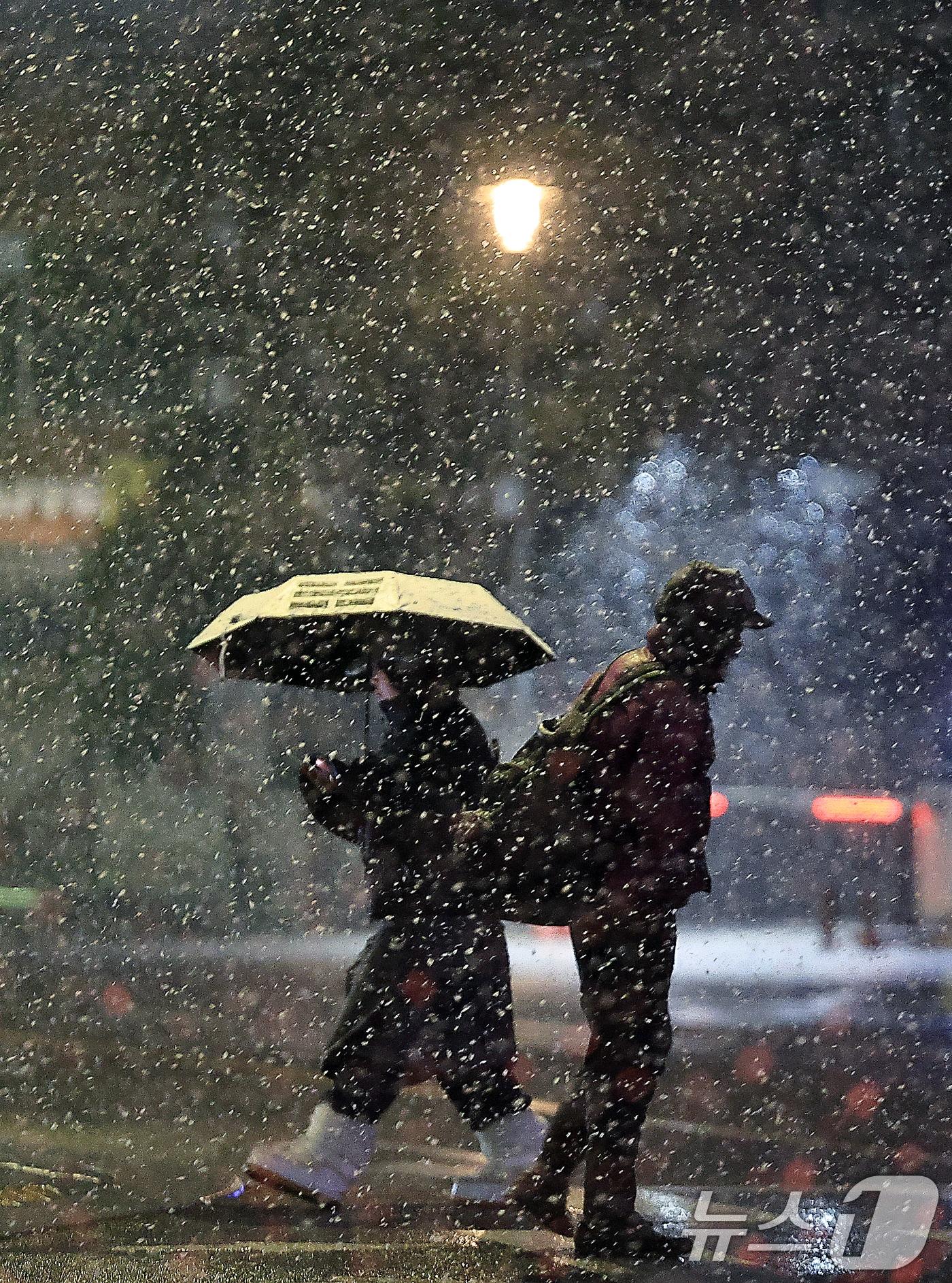 본문 이미지 - 수도권과 충남 지역에 대설특보가 발효된 가운데 18일 새벽 서울 종로구 도심을 지나는 시민들이 거센 눈발을 피해 발걸음을 재촉하고 있다.  2025.3.18/뉴스1 ⓒ News1 박정호 기자