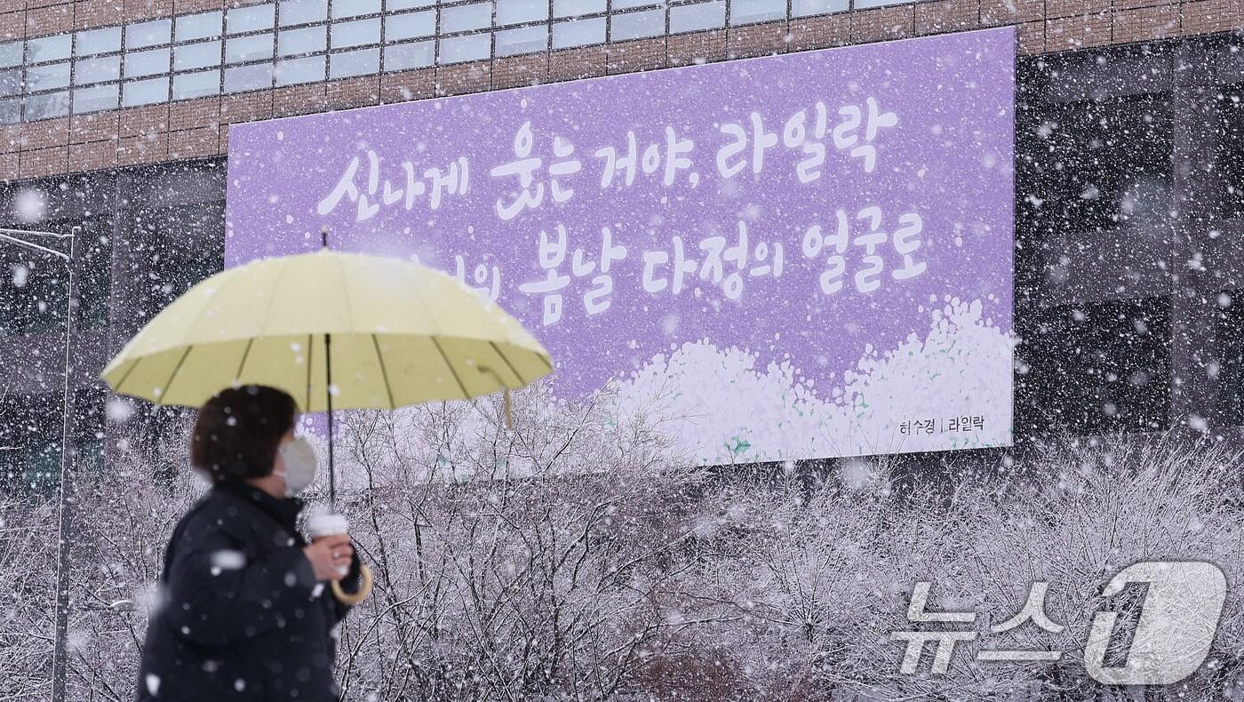 난데없는 3월 대설주의보가 발효된 18일 오전 서울 광화문광장에서 한 시민이 광화문 봄글판 앞으로 지나가고 있다. 2025.3.18/뉴스1 ⓒ News1 박지혜 기자