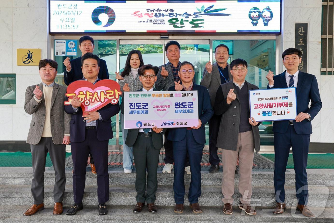 본문 이미지 - 진도군과 완도군 세무회계과 직원들이 고향사랑기부금 상호 전달 한 뒤 기념사진을 찍고 있다.(진도군 제공, 재판매 및 DB금지) 