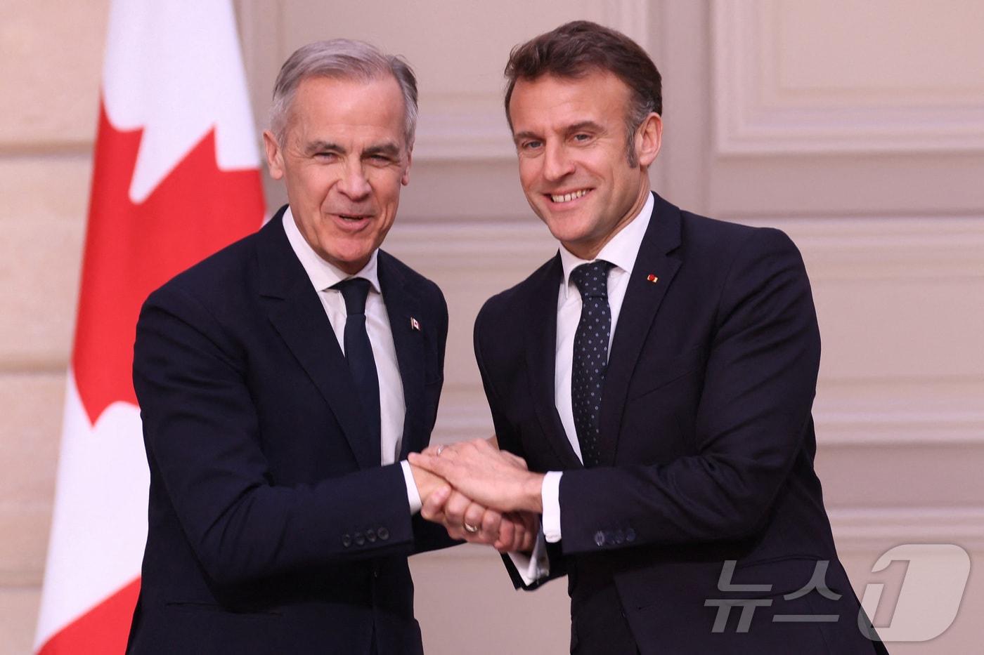 17일(현지시간) 에마뉘엘 마크롱 프랑스 대통령(오른쪽)과 마크 카니 캐나다 총리가 프랑스 파리 엘리제궁에서 공동 기자회견 이후 악수하고 있다. 2025.03.17 ⓒ 로이터=뉴스1 ⓒ News1 김지완 기자