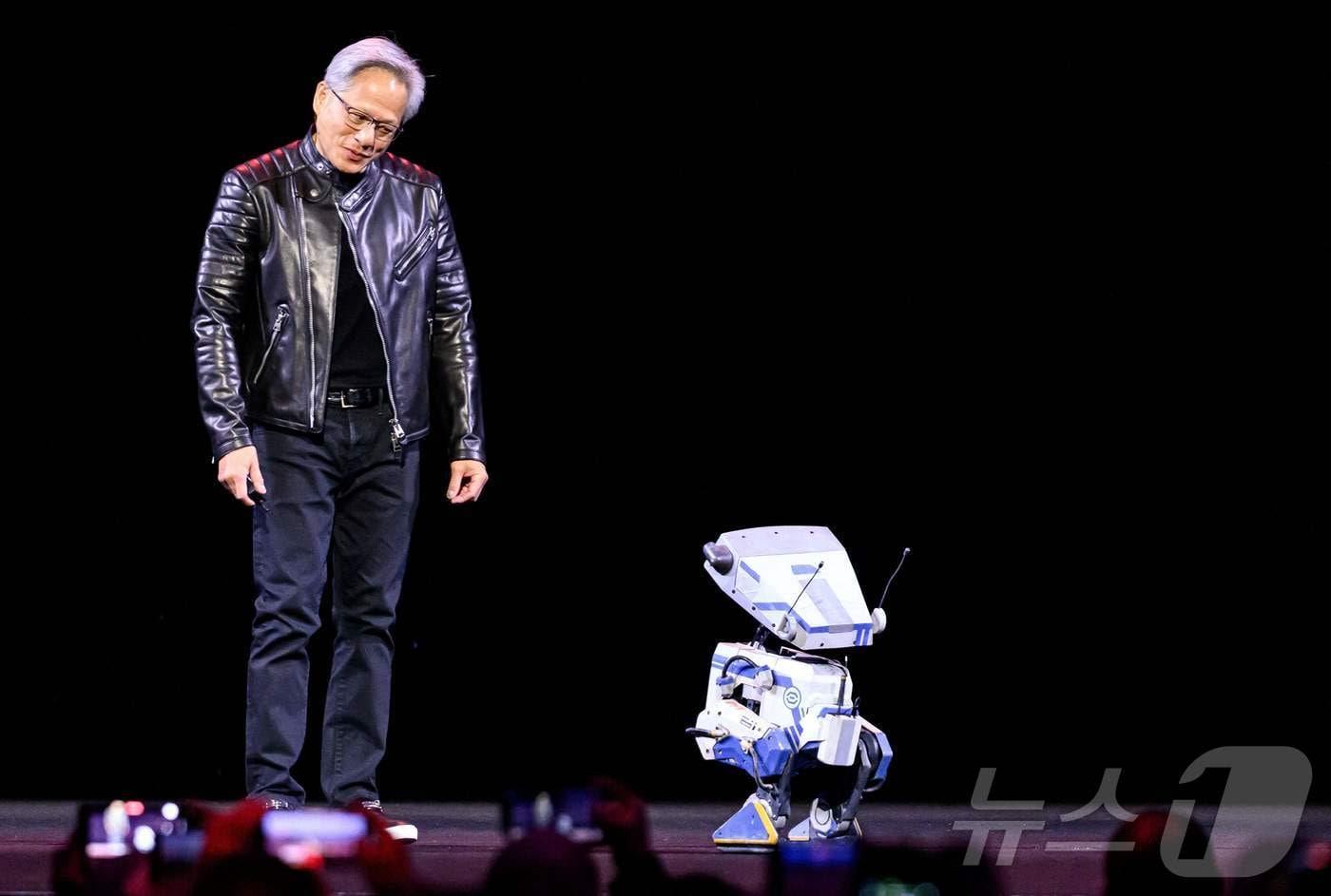 미국 캘리포니아 새너제이 SAP 센터에서 열린 기조연설 세션에서 엔비디아 CEO 젠슨 황이 로봇과 대화를 나누고 있다.2025.3.18ⓒ AFP=뉴스1