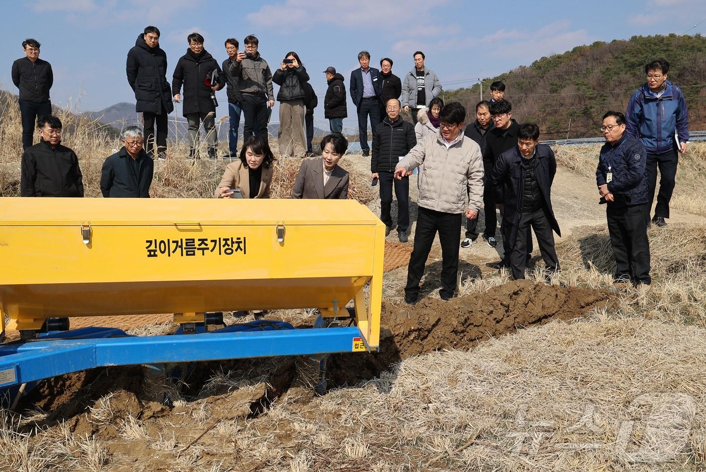 본문 이미지 - 권재한 농촌진흥청장이 충남 공주에 있는 현장 실증연구 논 시험 재배지에서 '깊이거름주기 장치 시연회'를 지켜보고 있다. /2025.3.19/(농진청 제공)