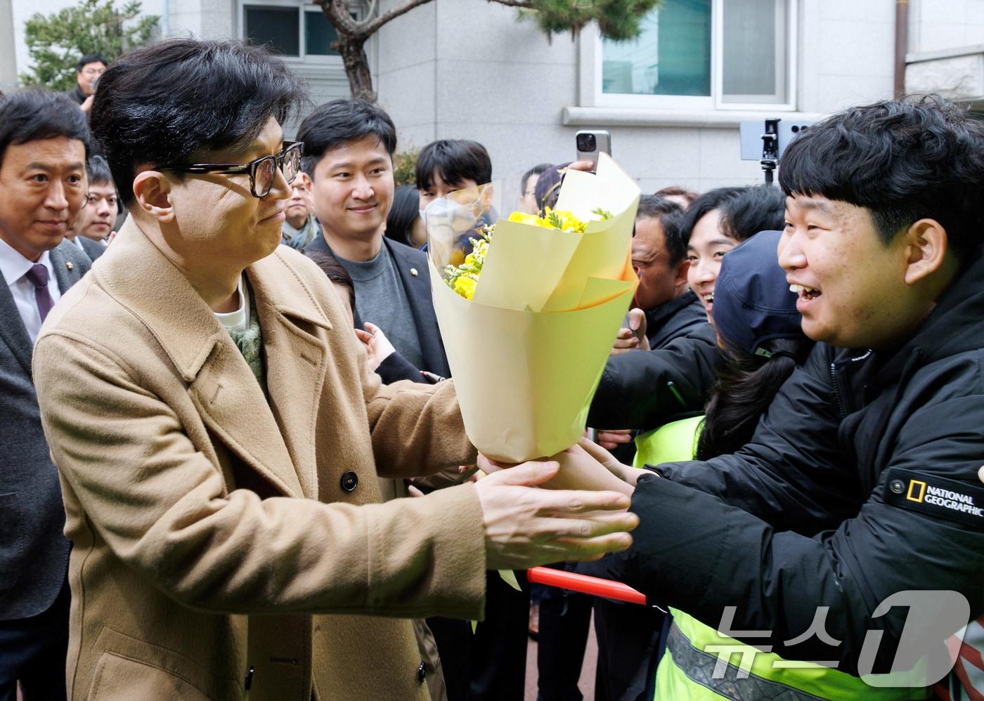 한동훈 국민의힘 전 대표가 2일 오후 서울 종로구 나온 씨어터에서 제2연평해전을 다룬 공연 '바다는 비에 젖지 않는다'를 관람하기 위해 이동하며 지지자들에게 꽃다발을 받고 있다. (공동취재) 2025.3.2/뉴스1 ⓒ News1 김명섭 기자