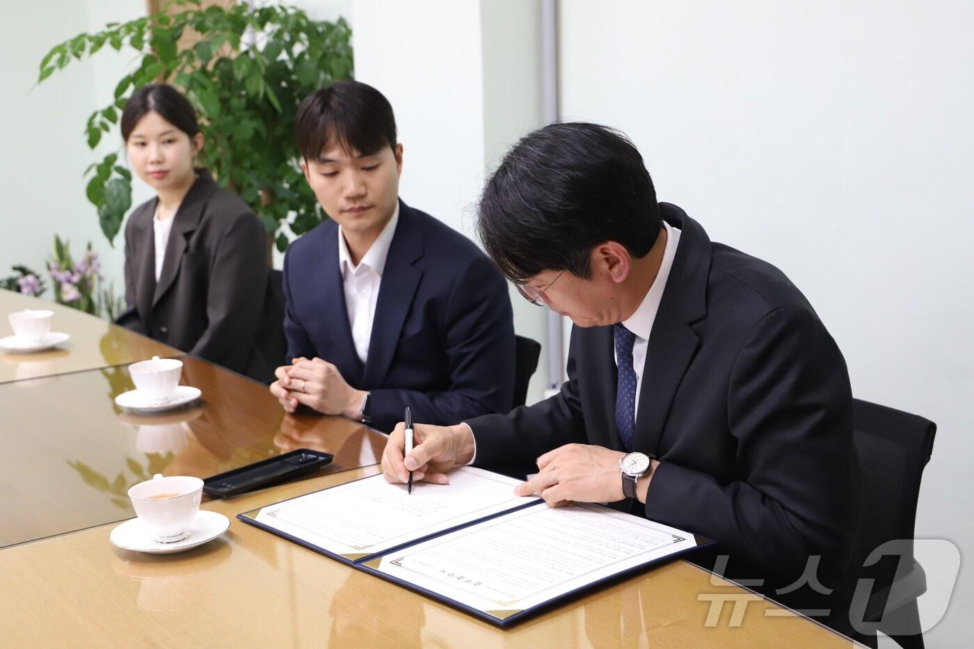 김강진 더현대 대구 점장&#40;오른쪽&#41;이 대구문화예술진흥원과의 예술인 생활편의 복지 증진과 상호협력을 위한 업무협약서에 사인을 하고 있다.&#40;더현대 대구 제공. 재판매 및 DB 금지&#41;