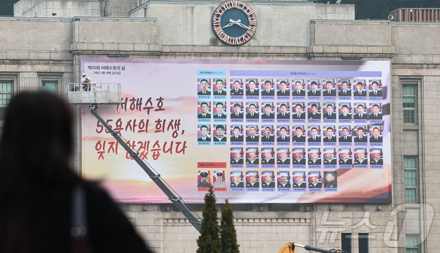 21일 오전 서울 중구 서울도서관 외벽에 서해수호의 날(3월 28일)을 맞아 용사들 한 명 한 명의 이름과 사진이 담긴 꿈새김판이 설치되고 있다. 서해수호의 날은 2002년 제2연평해전, 2010년 천안함 피격사건과 연평도 포격전으로 희생된 우리 군인 55명을 기리고자 2016년에 제정된 법정기념일이다. 2025.3.21/뉴스1 ⓒ News1 김도우 기자